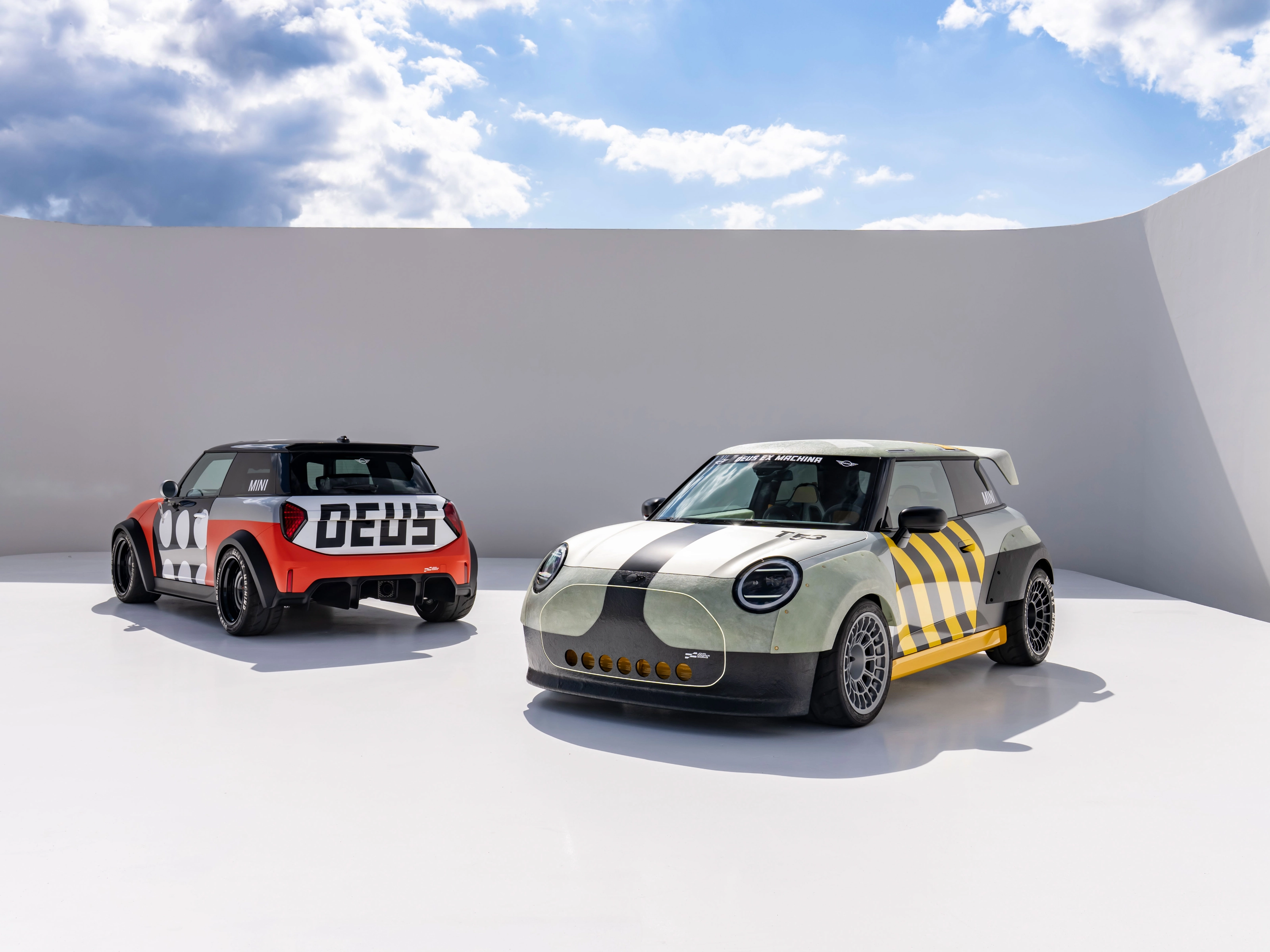 Two customized Mini cars parked in a minimalist outdoor setting.