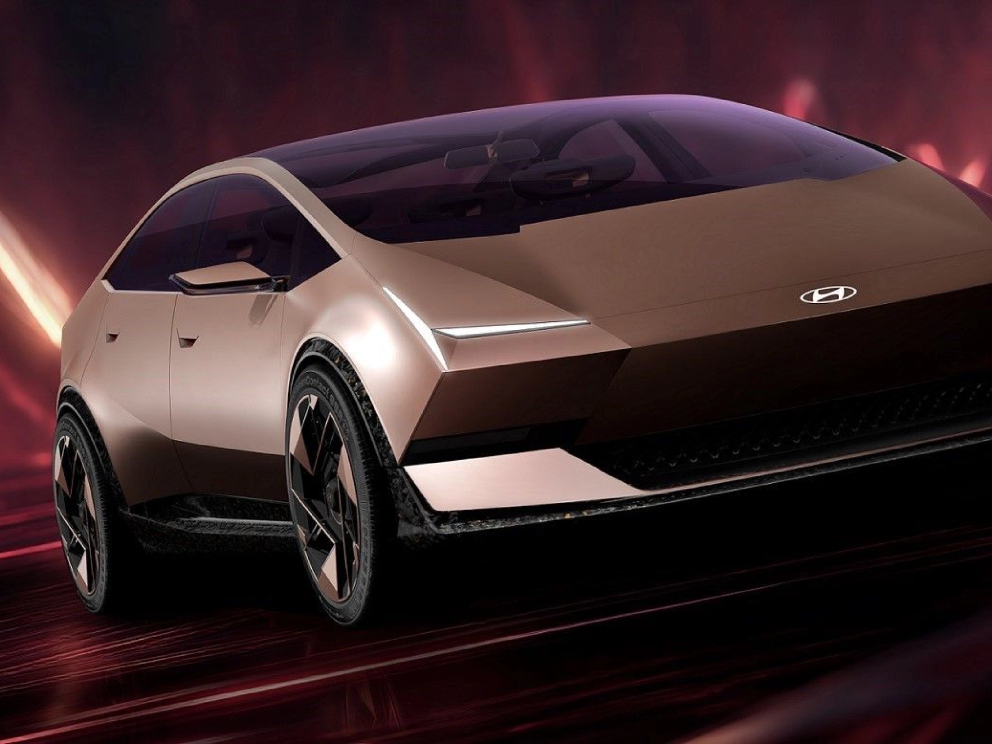 Futuristic Hyundai electric car driving in a red illuminated studio setting.