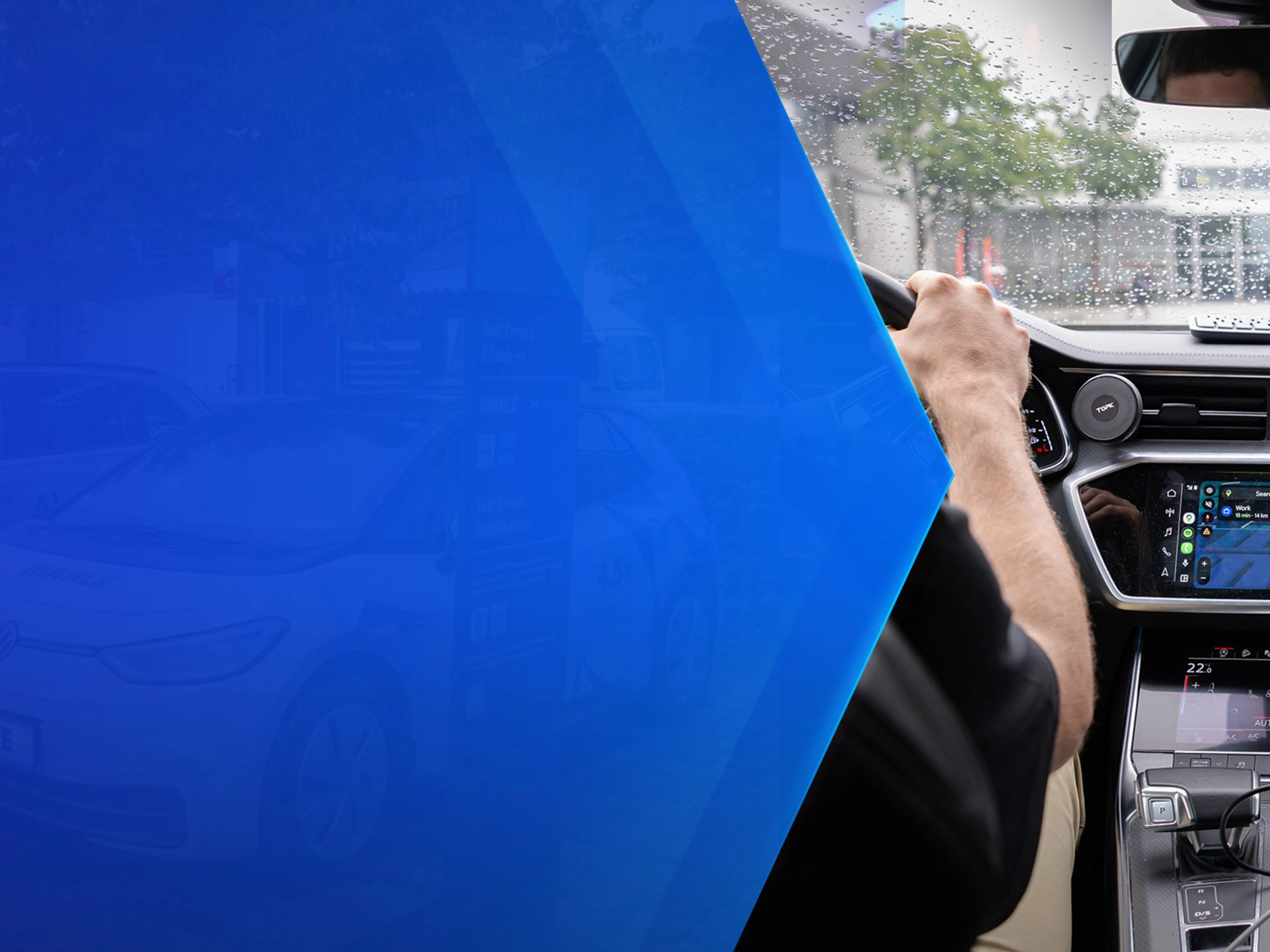 Driver tests in-car technology with navigation and monitoring screens during rainy conditions.