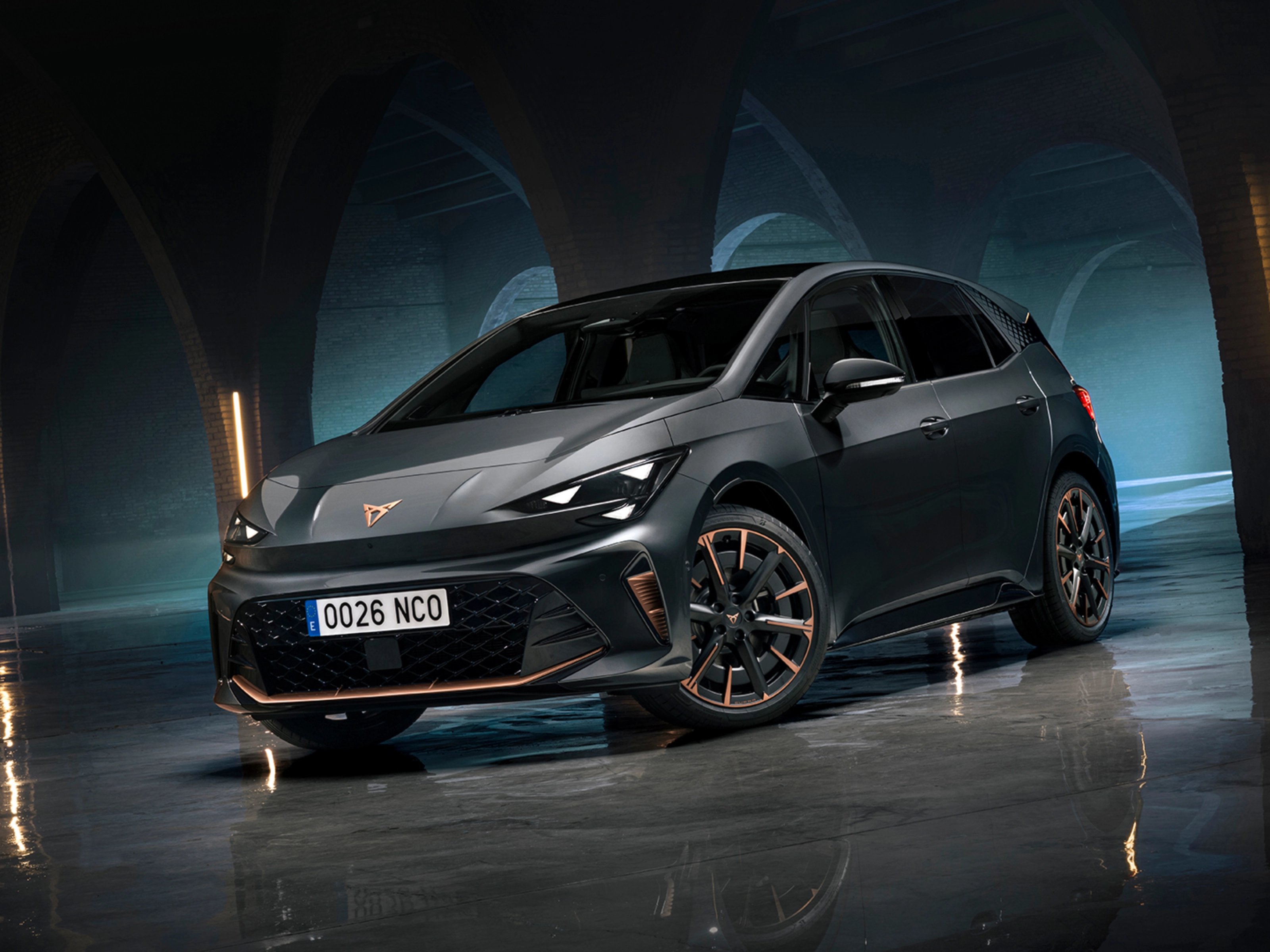 CUPRA Elektroauto steht in einer dunklen Halle mit Bögen und spiegelndem Boden.