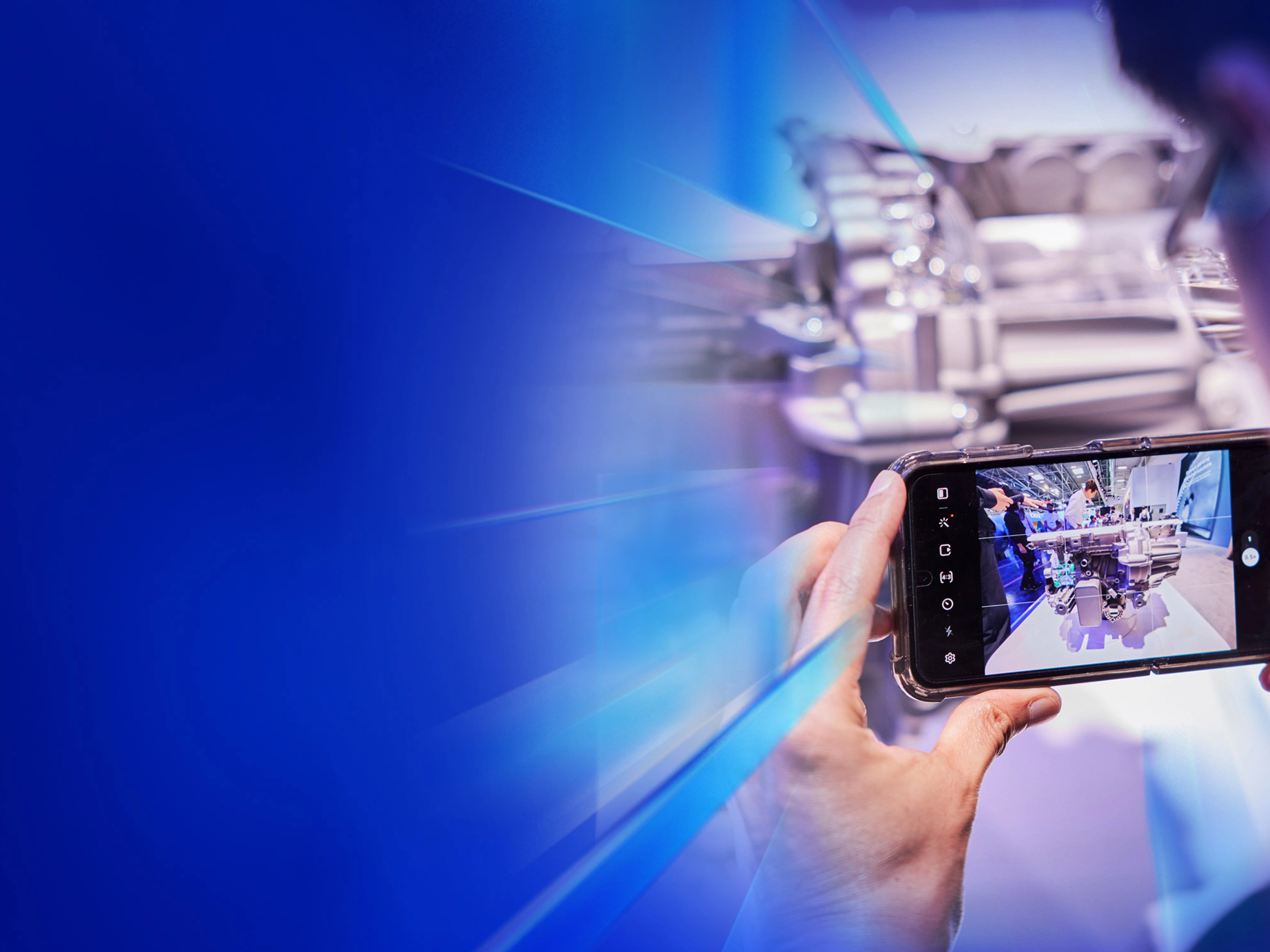 Eine Person fotografiert ein technisches Exponat mit dem Smartphone auf dem IAA Summit.