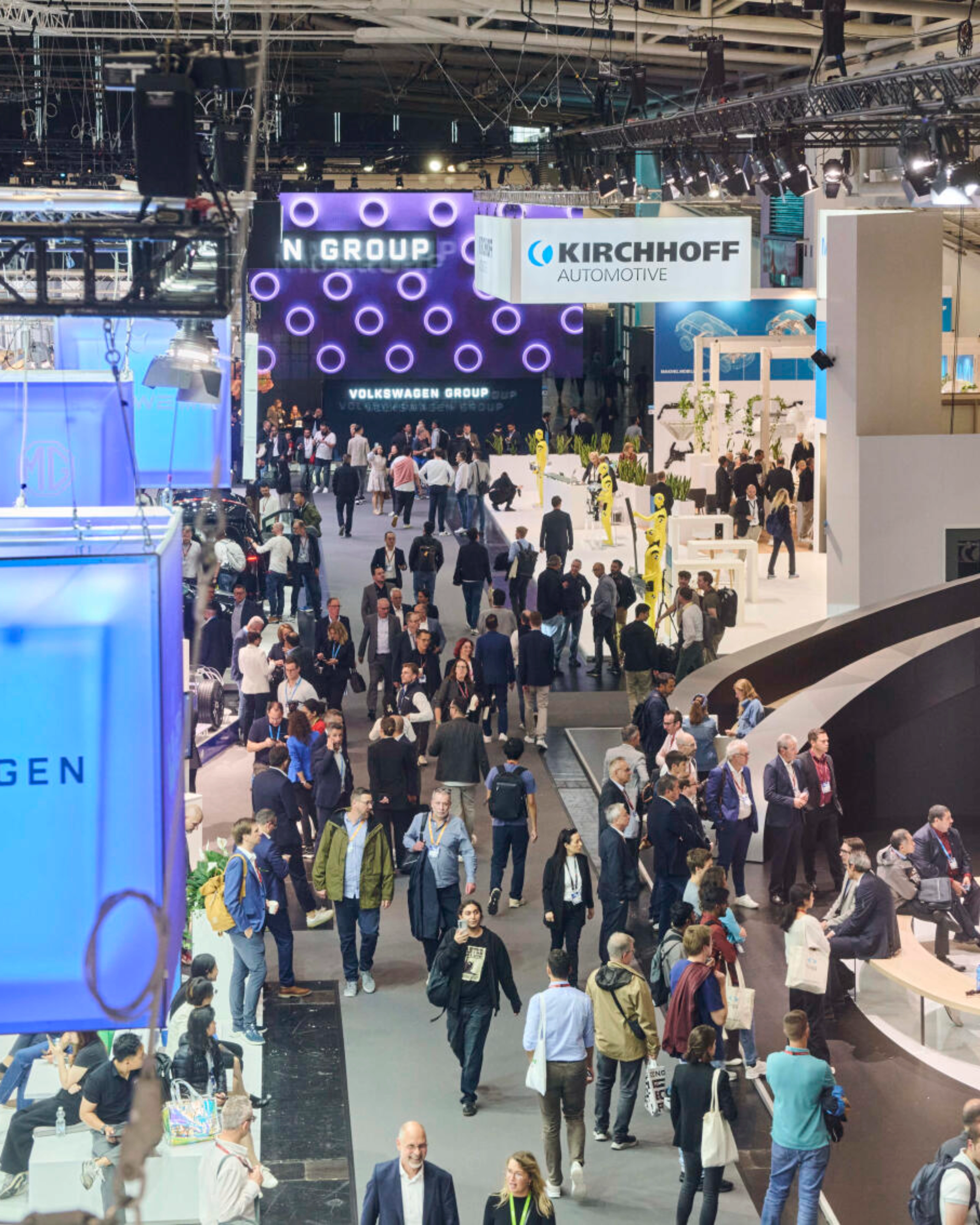 Menschen besuchen den Stand der Volkswagen Group auf einer Messe.