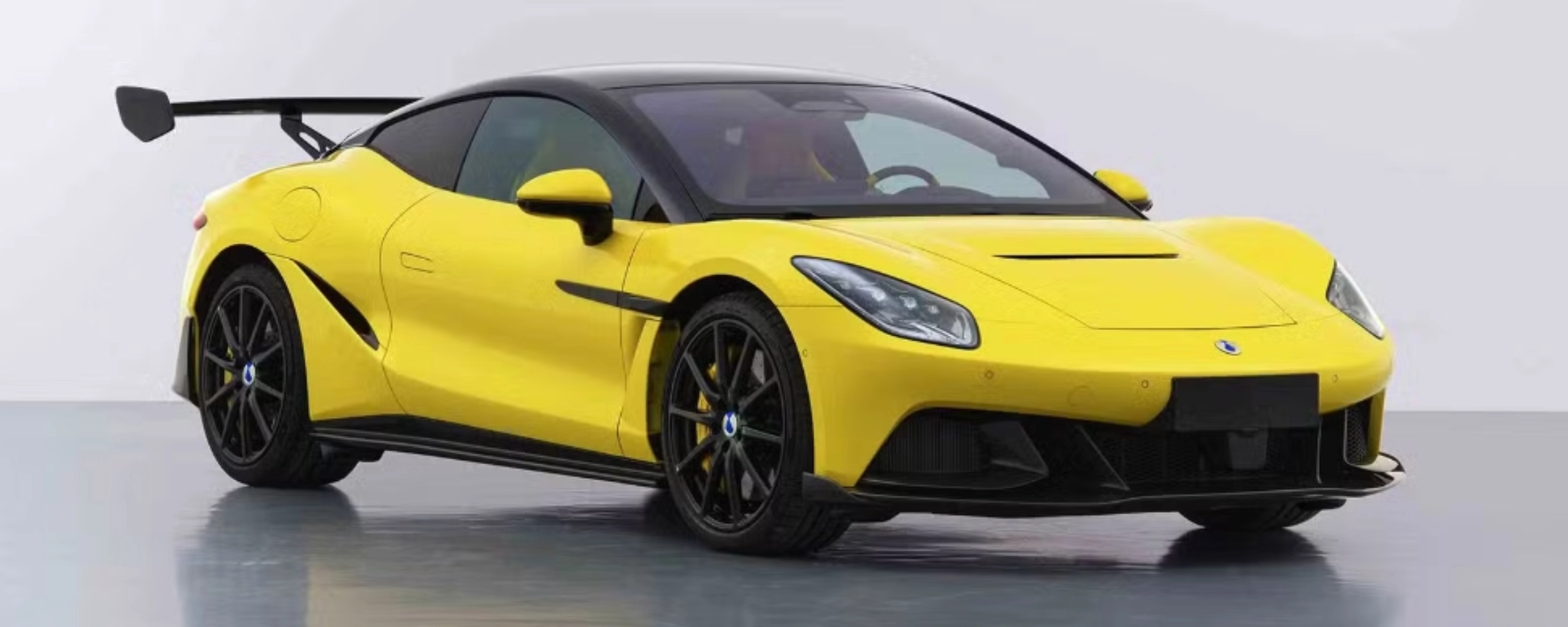 Yellow Denza Z sports car by BYD with rear wing on white studio background.