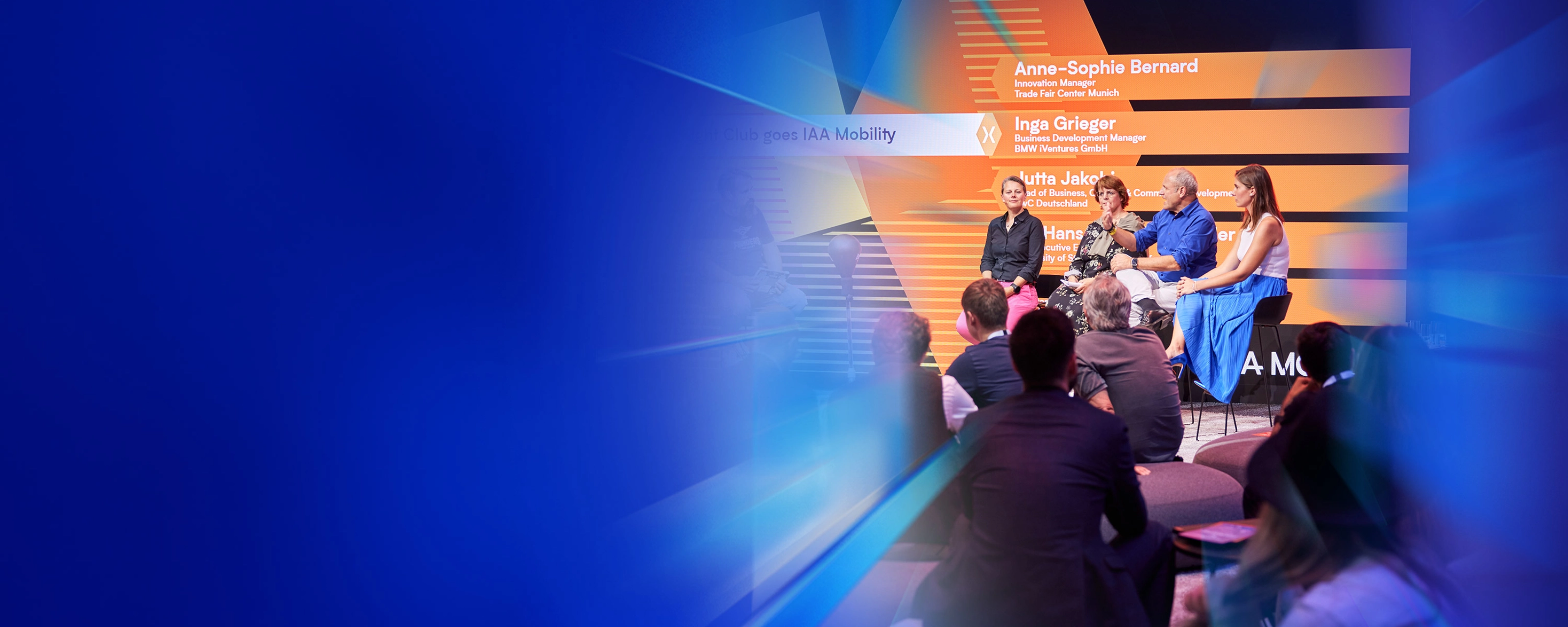 Ein Panel mit fünf Personen spricht auf der Bühne des IAA Summit, das Publikum hört zu.