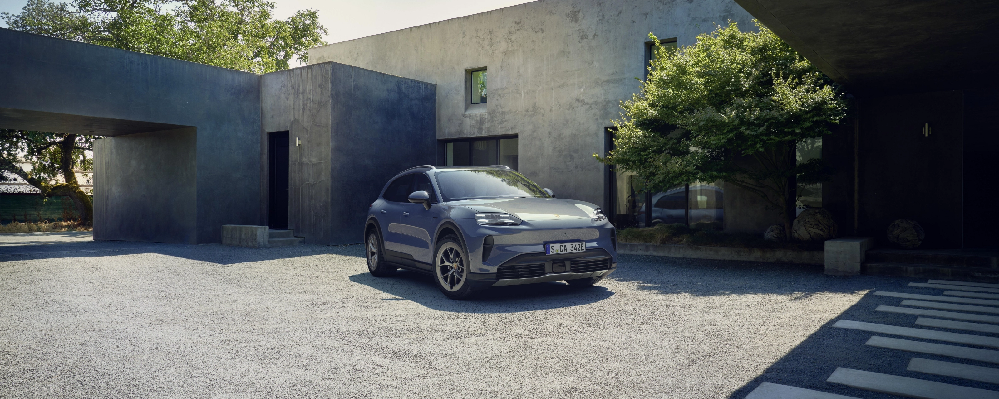Porsche Cayenne S parked in front of a modern house.