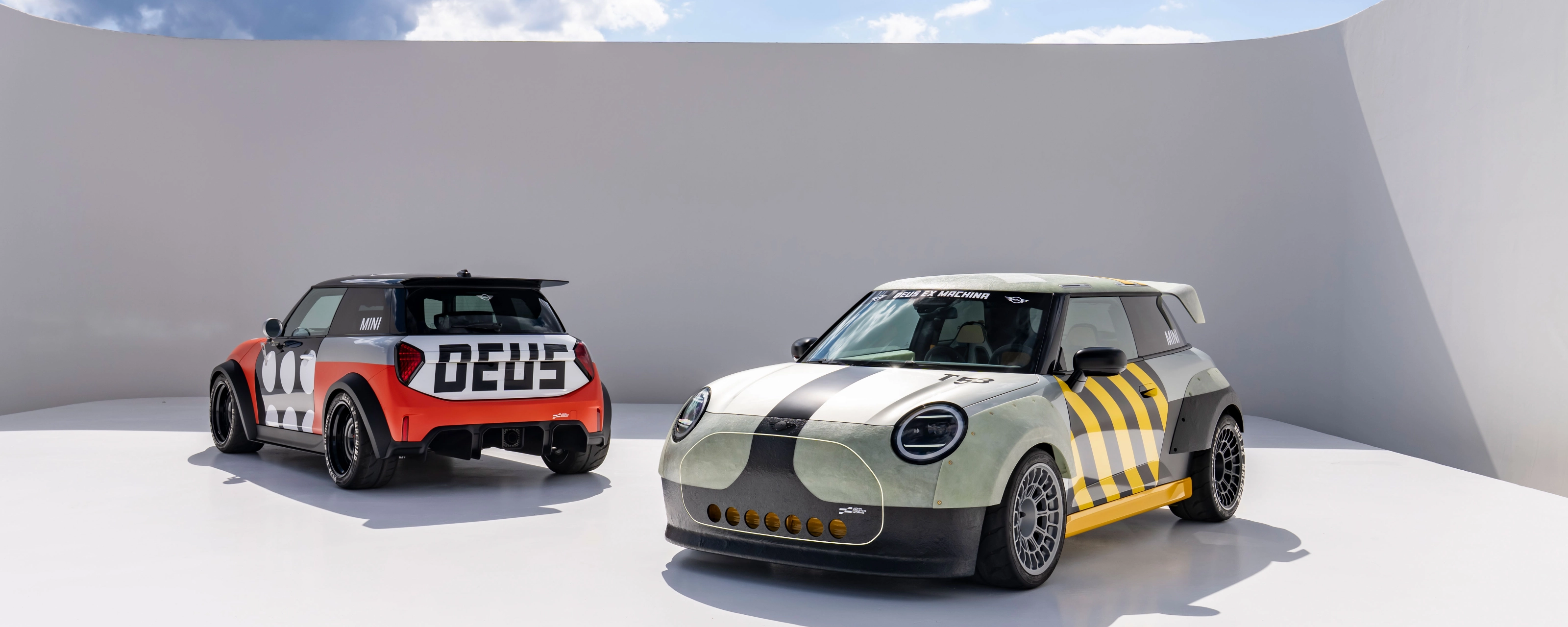 Two customized Mini cars parked in a minimalist outdoor setting.