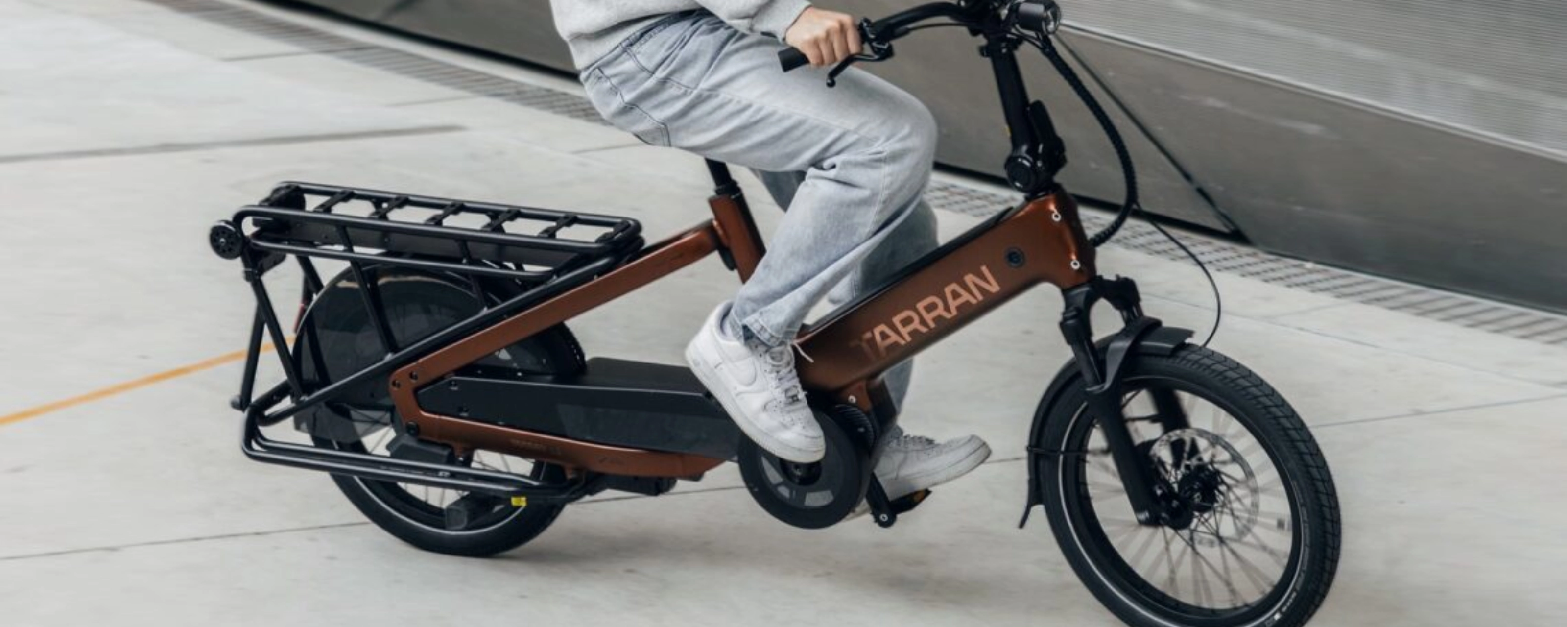 Person fährt ein Tarran Lasten-E-Bike in urbaner Umgebung.