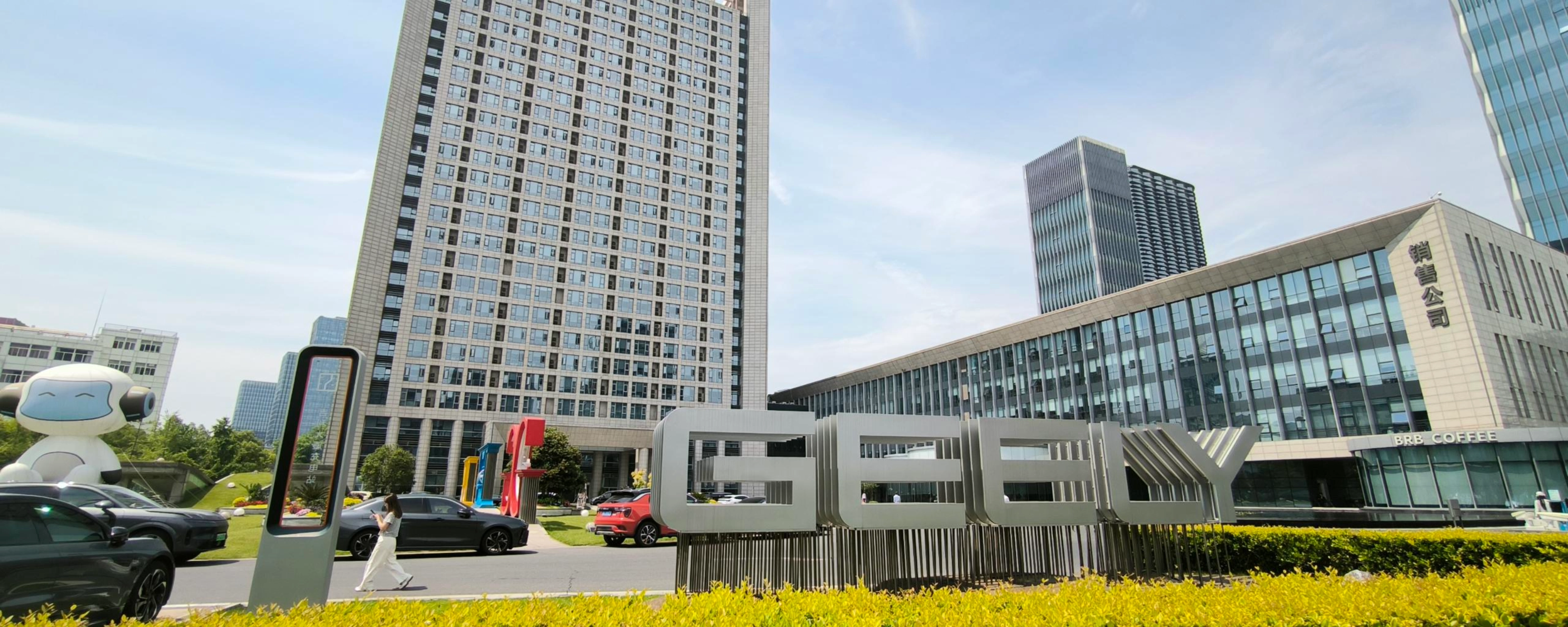 Geely-Logo vor einem modernen Bürogebäude.