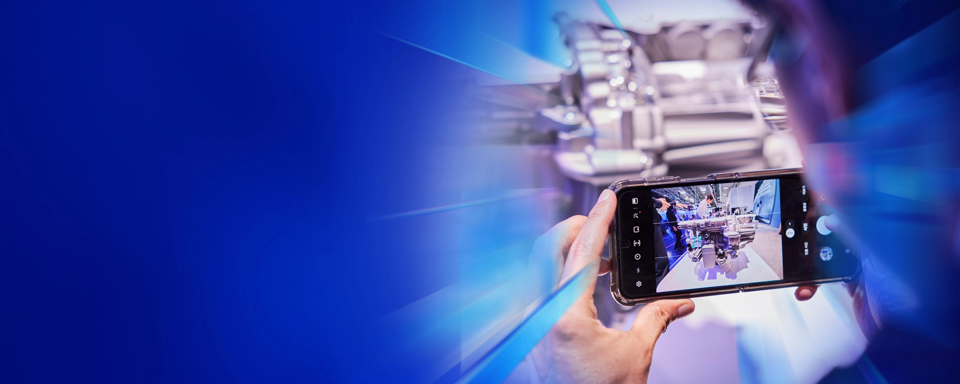 Eine Person fotografiert ein technisches Exponat mit dem Smartphone auf dem IAA Summit.
