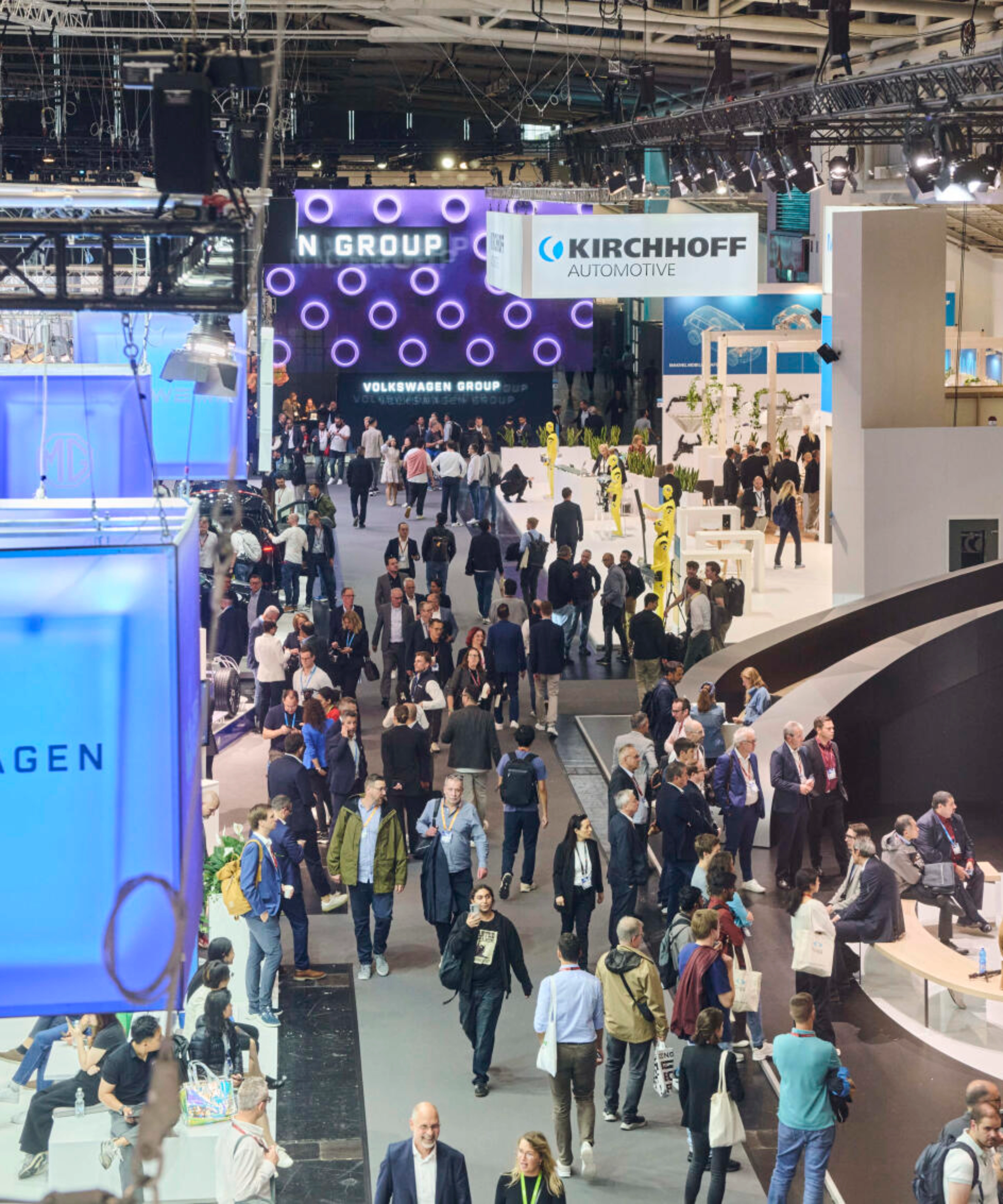 Menschen besuchen den Stand der Volkswagen Group auf einer Messe.