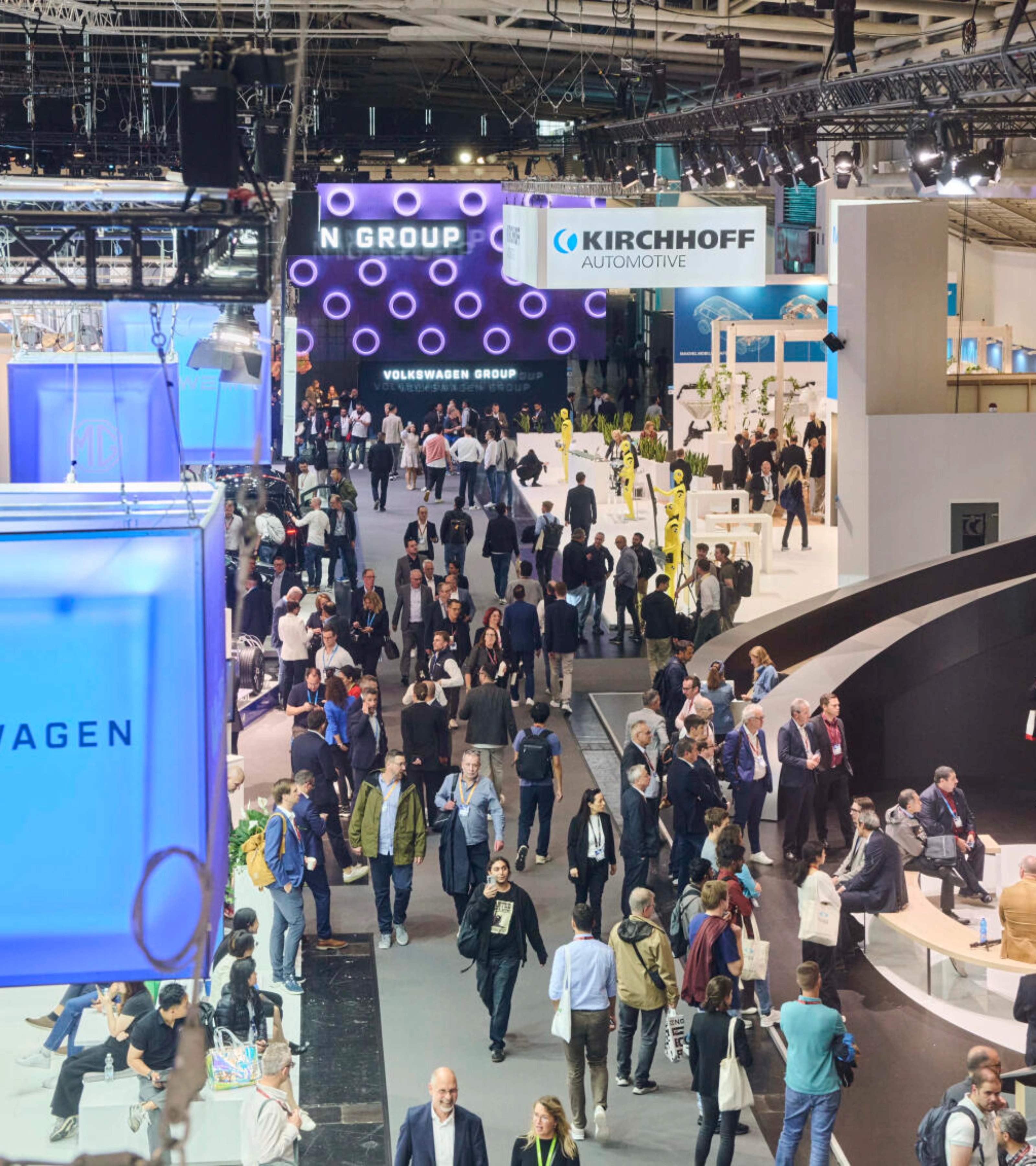 Menschen besuchen den Stand der Volkswagen Group auf einer Messe.