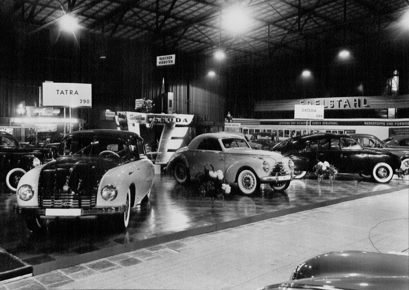 Klassische Automobile stehen in einer großen Ausstellungshalle auf einer historischen IAA.