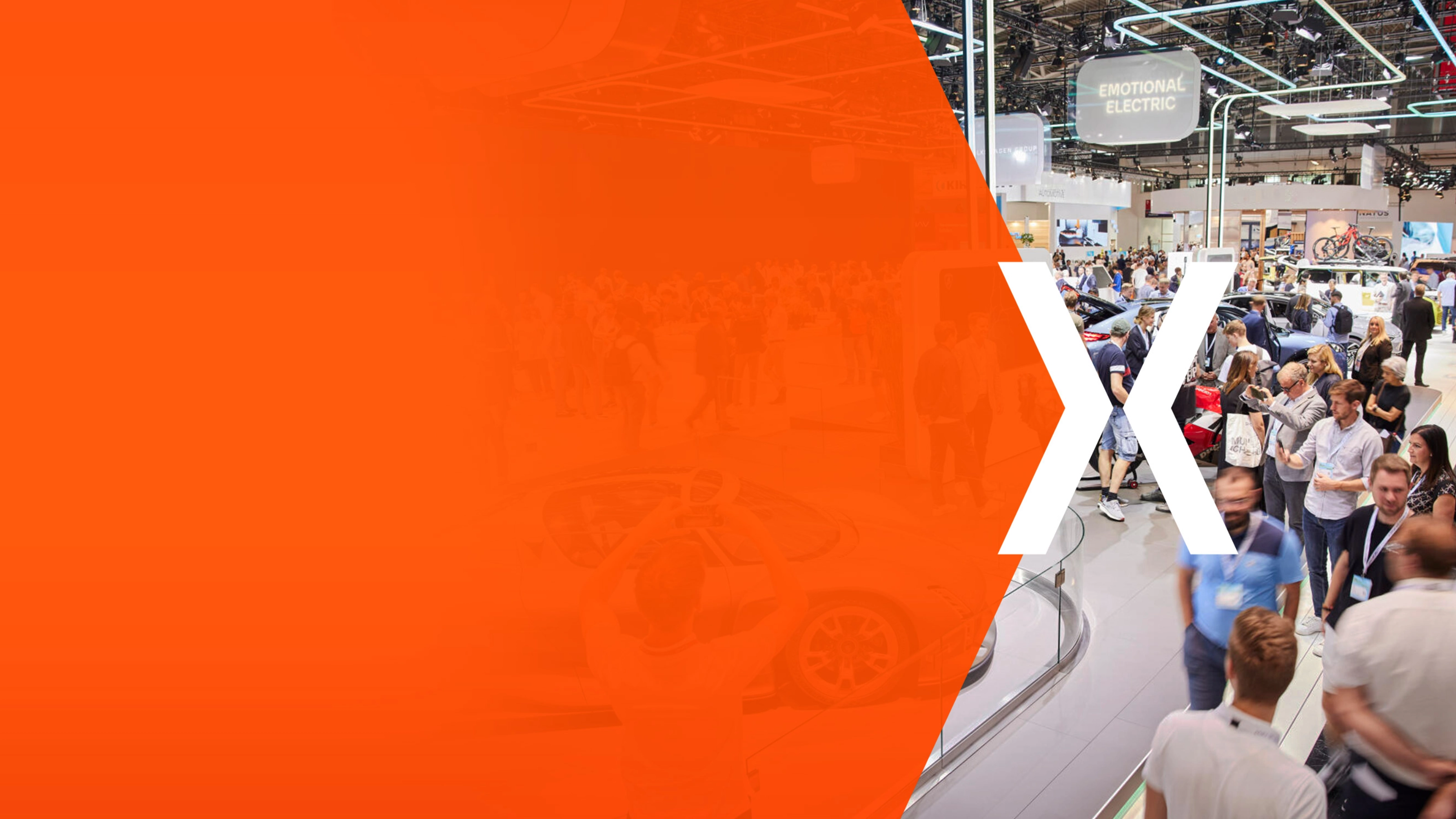 Trade fair hall with many visitors and an orange area featuring a large white X.