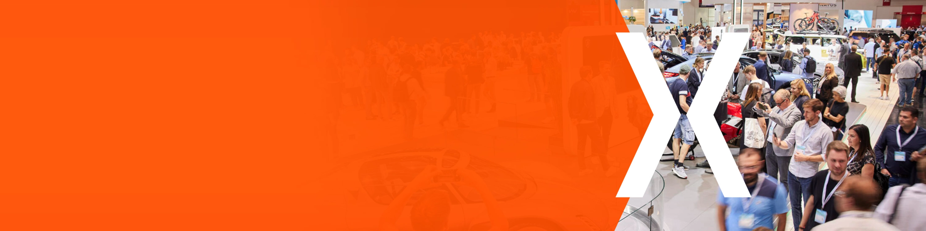 Trade fair hall with many visitors and an orange area featuring a large white X.