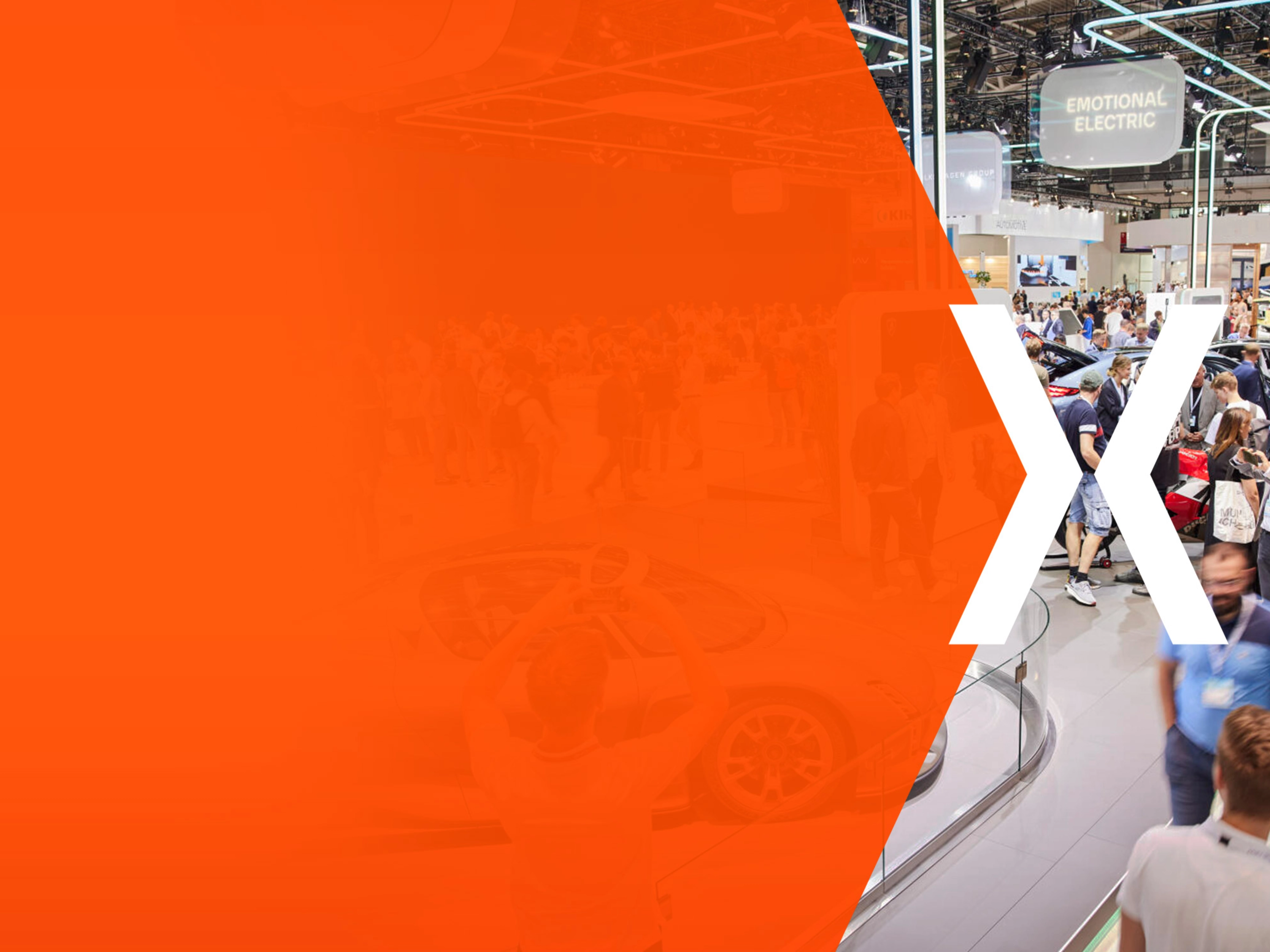 Trade fair hall with many visitors and an orange area featuring a large white X.