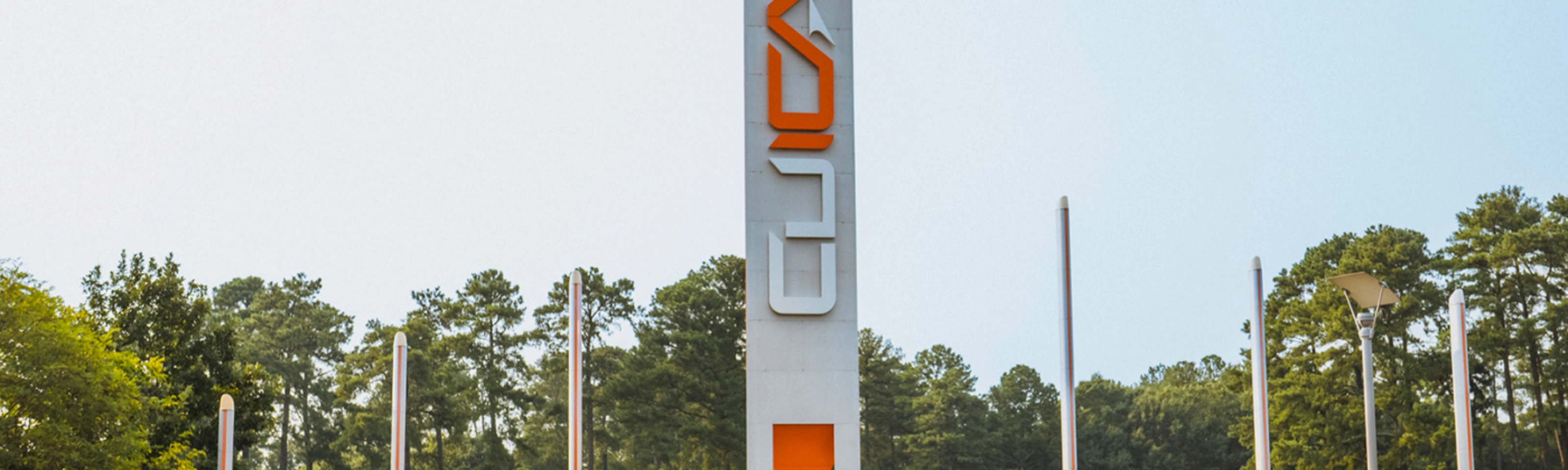Autonomous vehicle beside a CU-ICAR test tower at Clemson University.