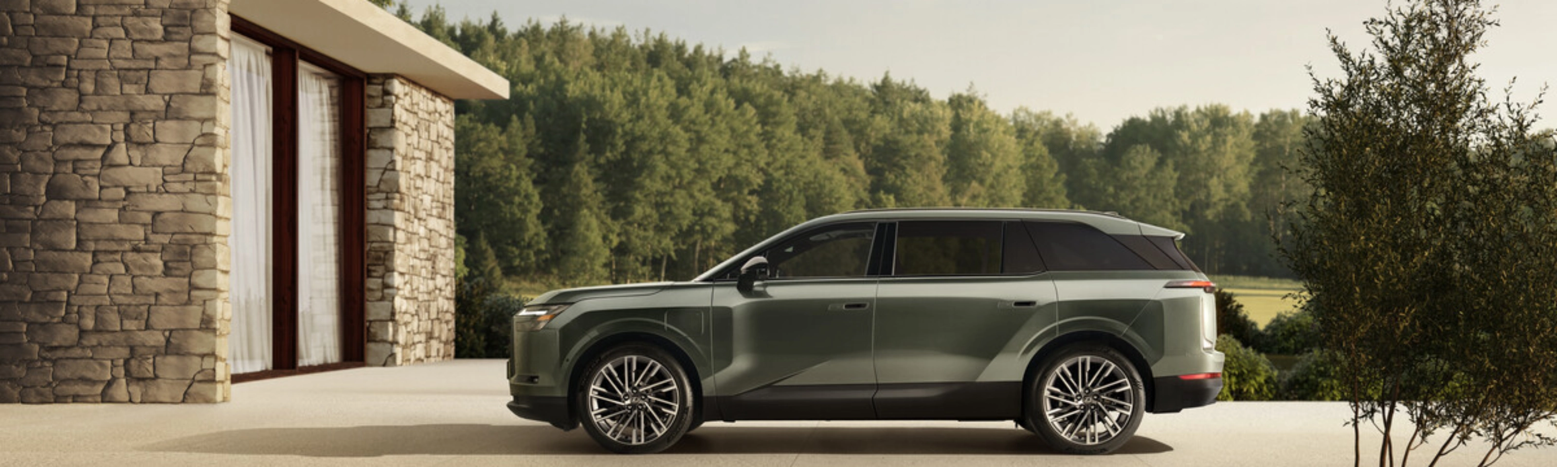 Grünes Toyota Elektro-SUV neben modernem Steinhaus geparkt.