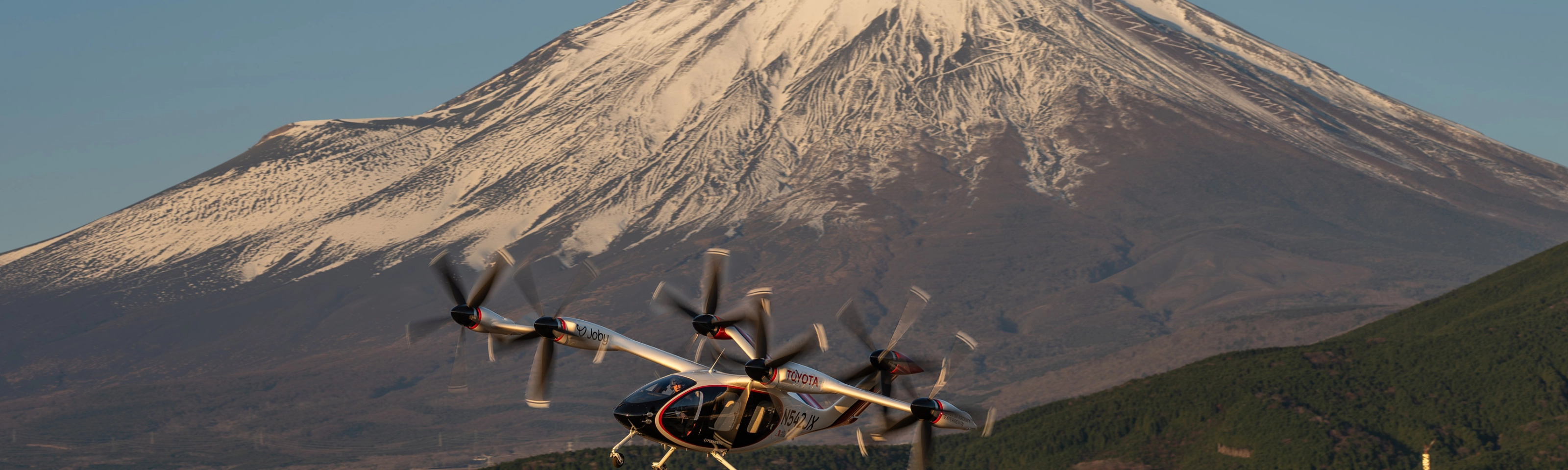 Elektrisches Flugtaxi von Joby Aviation vor dem Berg Fuji im Flug.