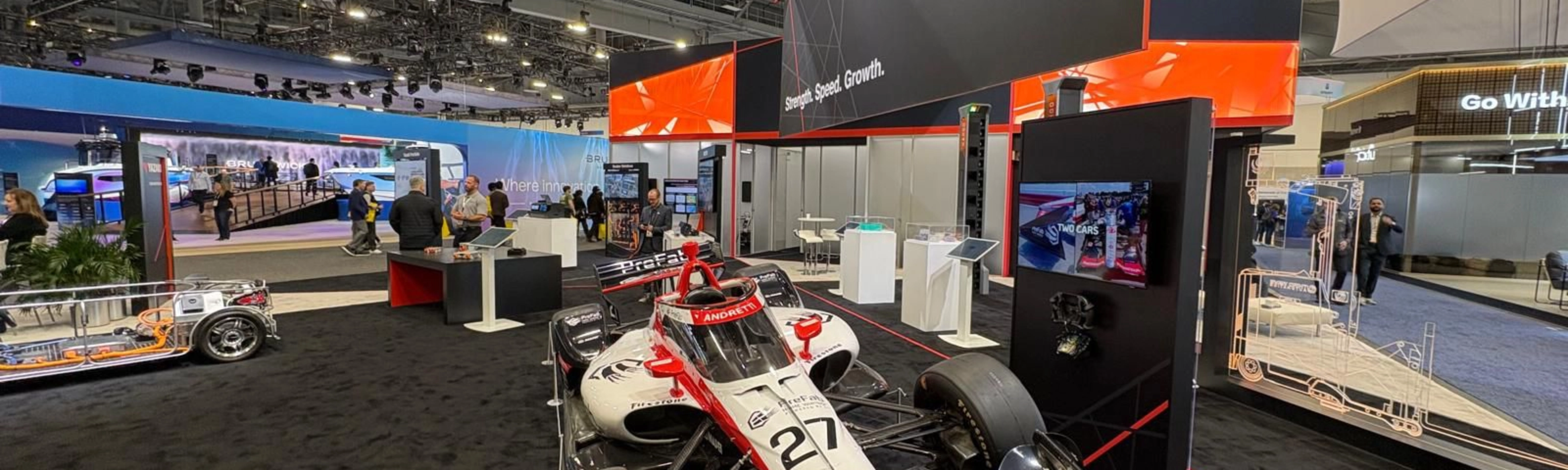 Ein Rennwagen steht am Messestand von Yazaki auf einer Technologiemesse.