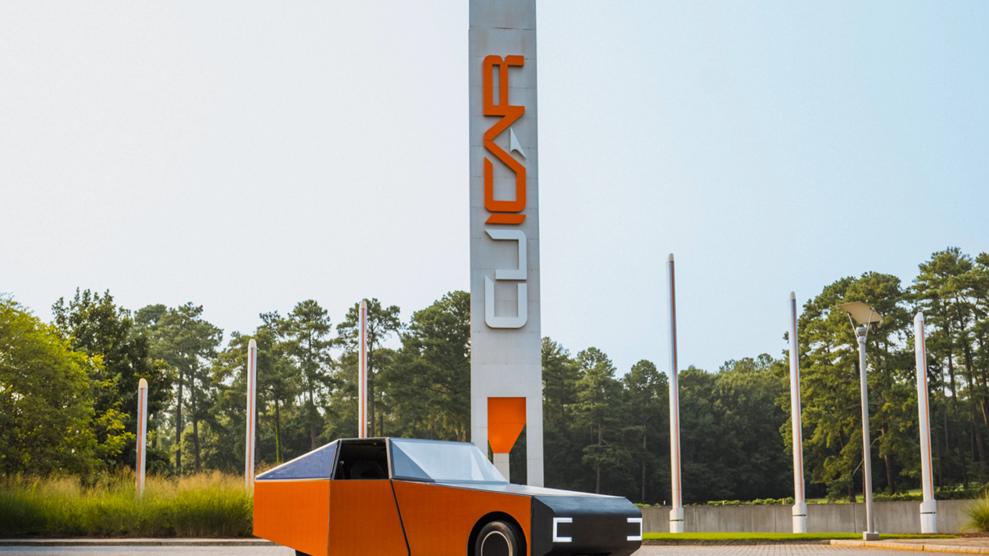 Autonomous vehicle beside a CU-ICAR test tower at Clemson University.
