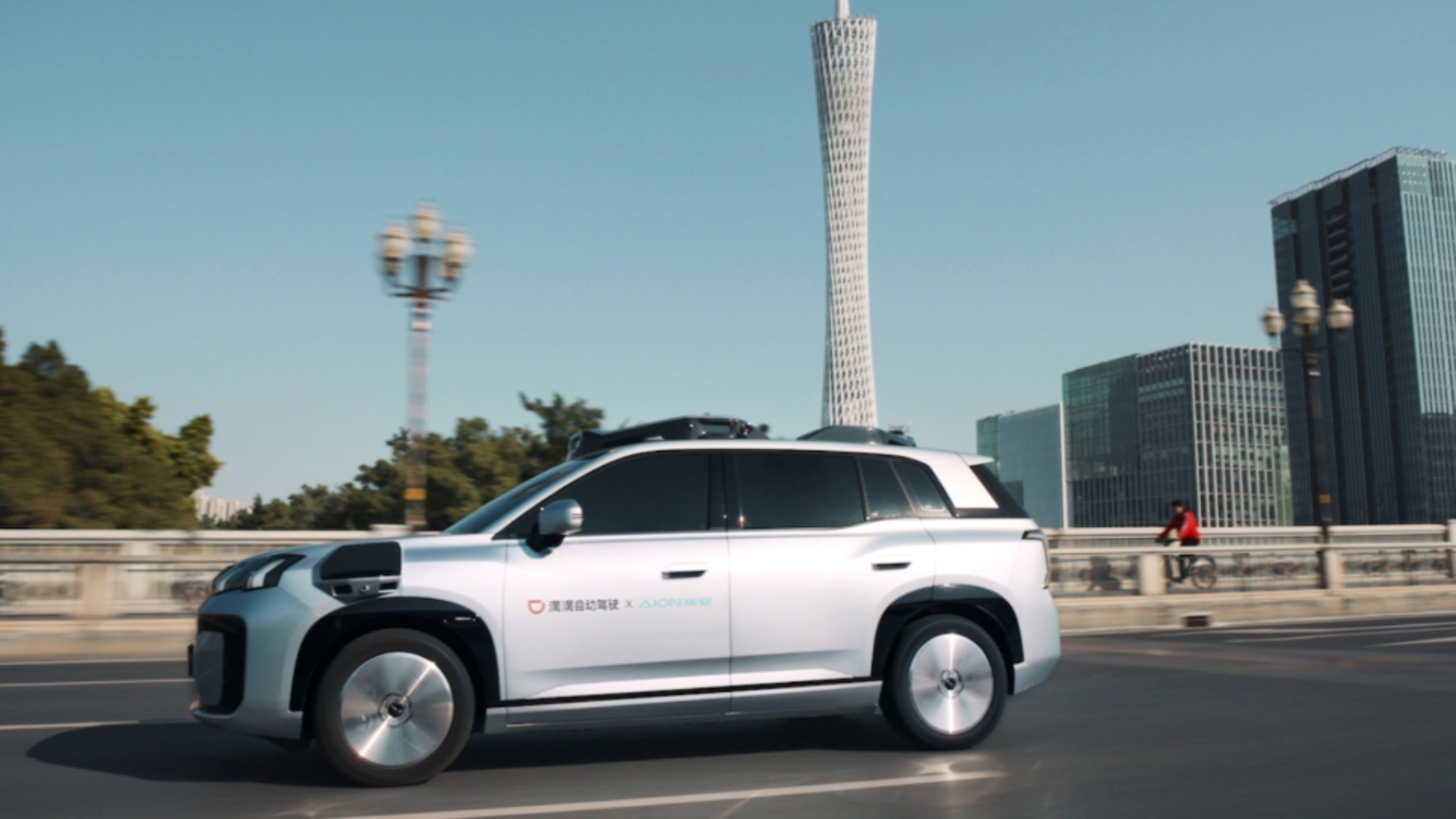 Ein autonomes SUV fährt durch eine Stadt mit modernen Gebäuden im Hintergrund.