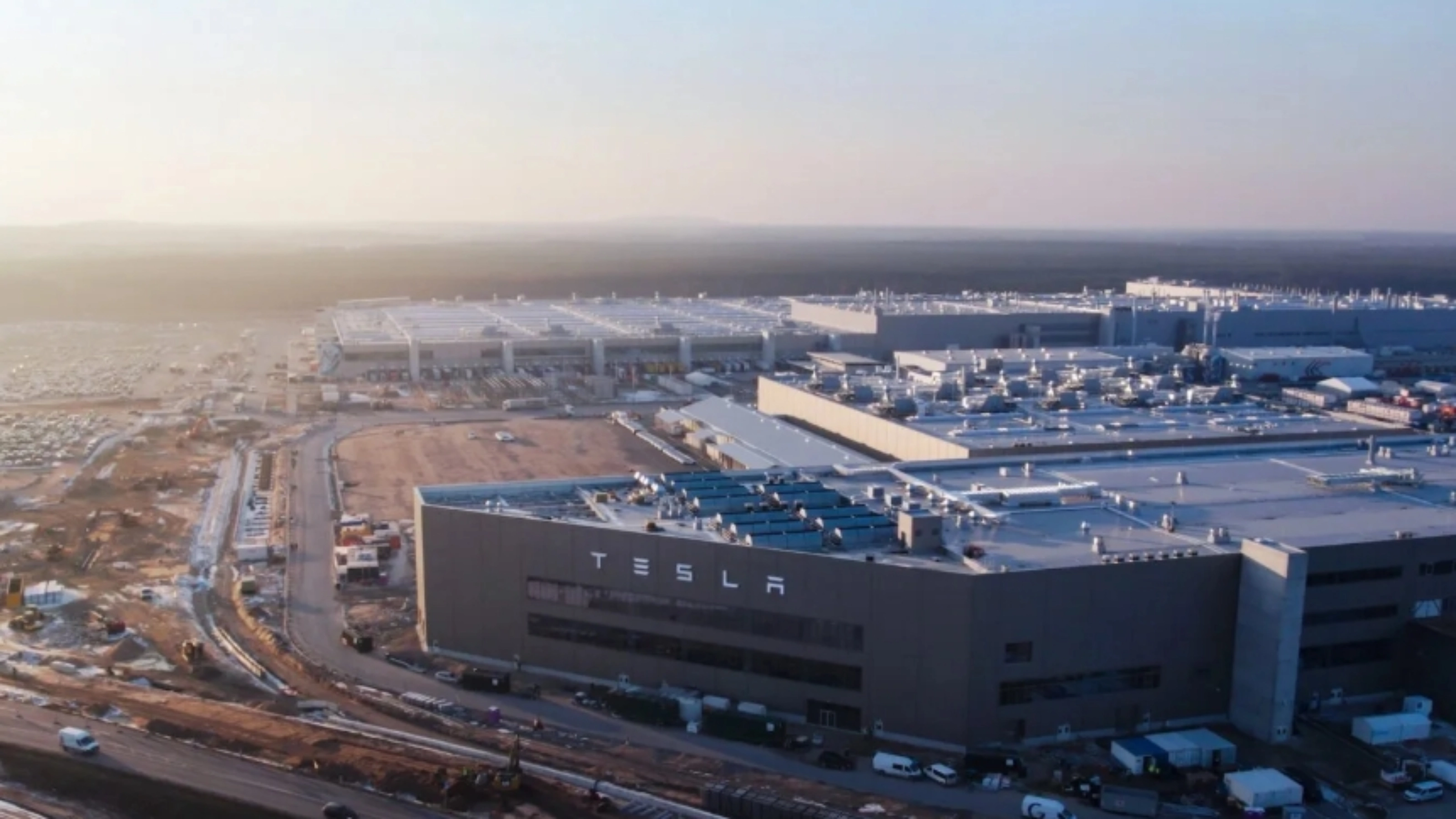 Luftaufnahme eines Tesla-Werks mit großen Produktionsgebäuden.
