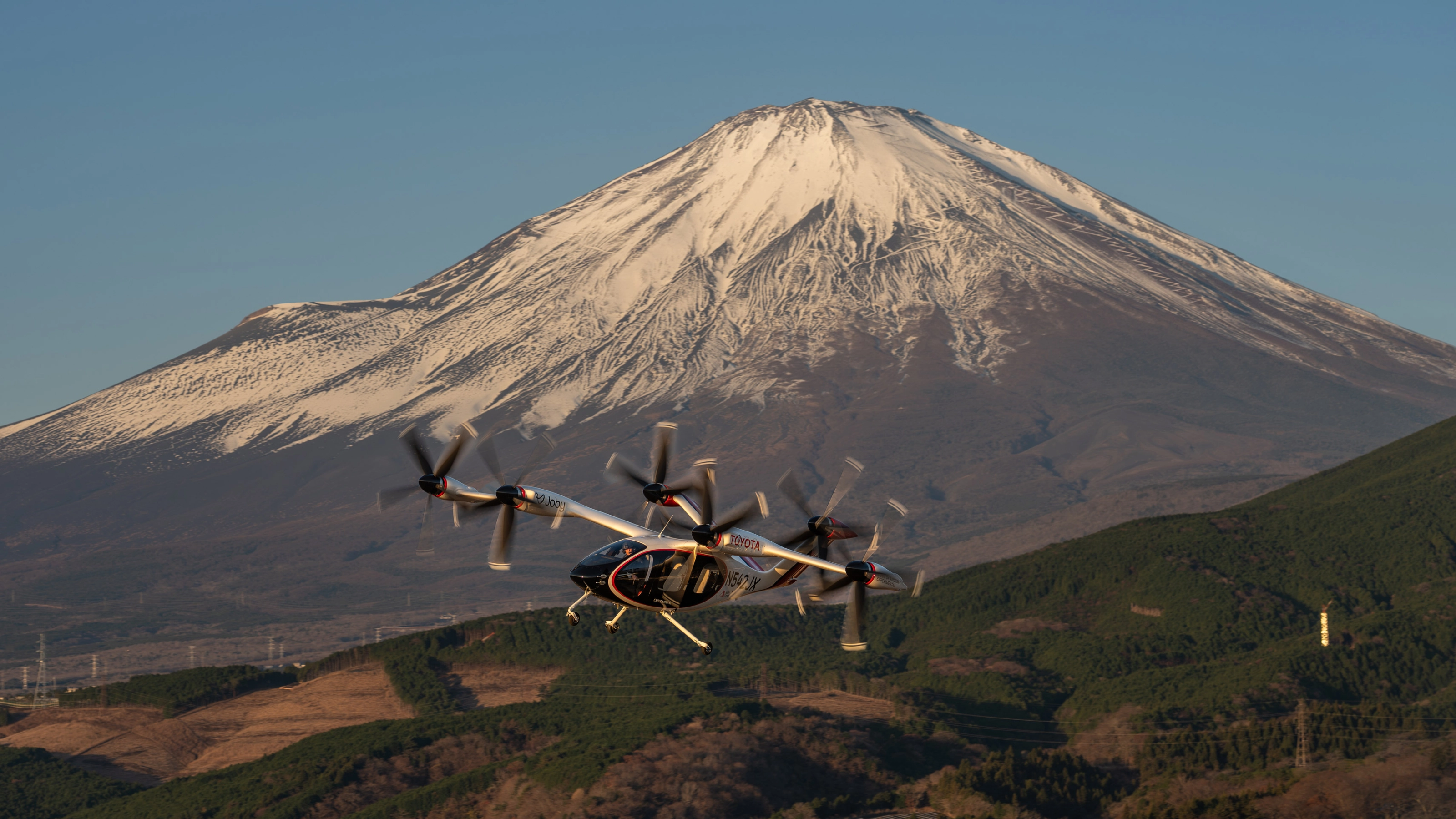Elektrisches Flugtaxi von Joby Aviation vor dem Berg Fuji im Flug.