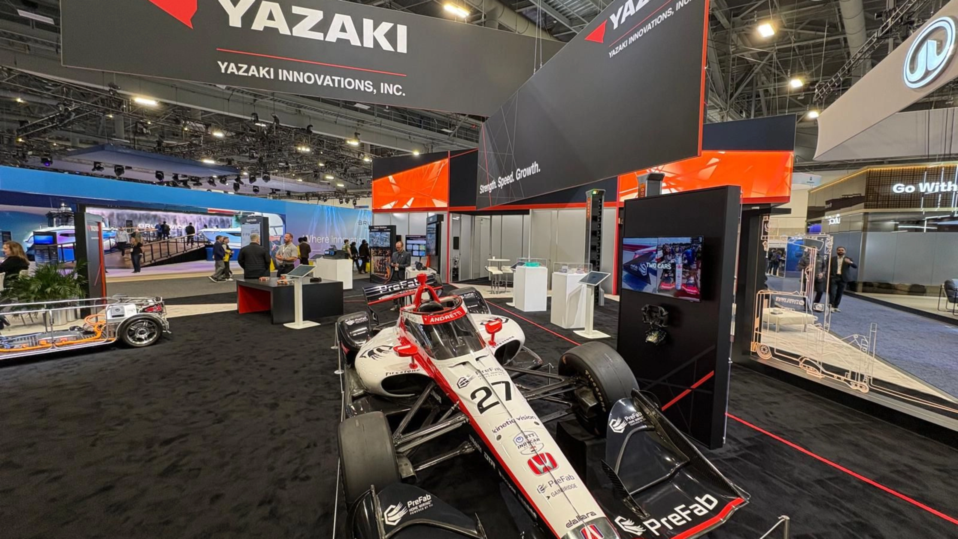 Ein Rennwagen steht am Messestand von Yazaki auf einer Technologiemesse.