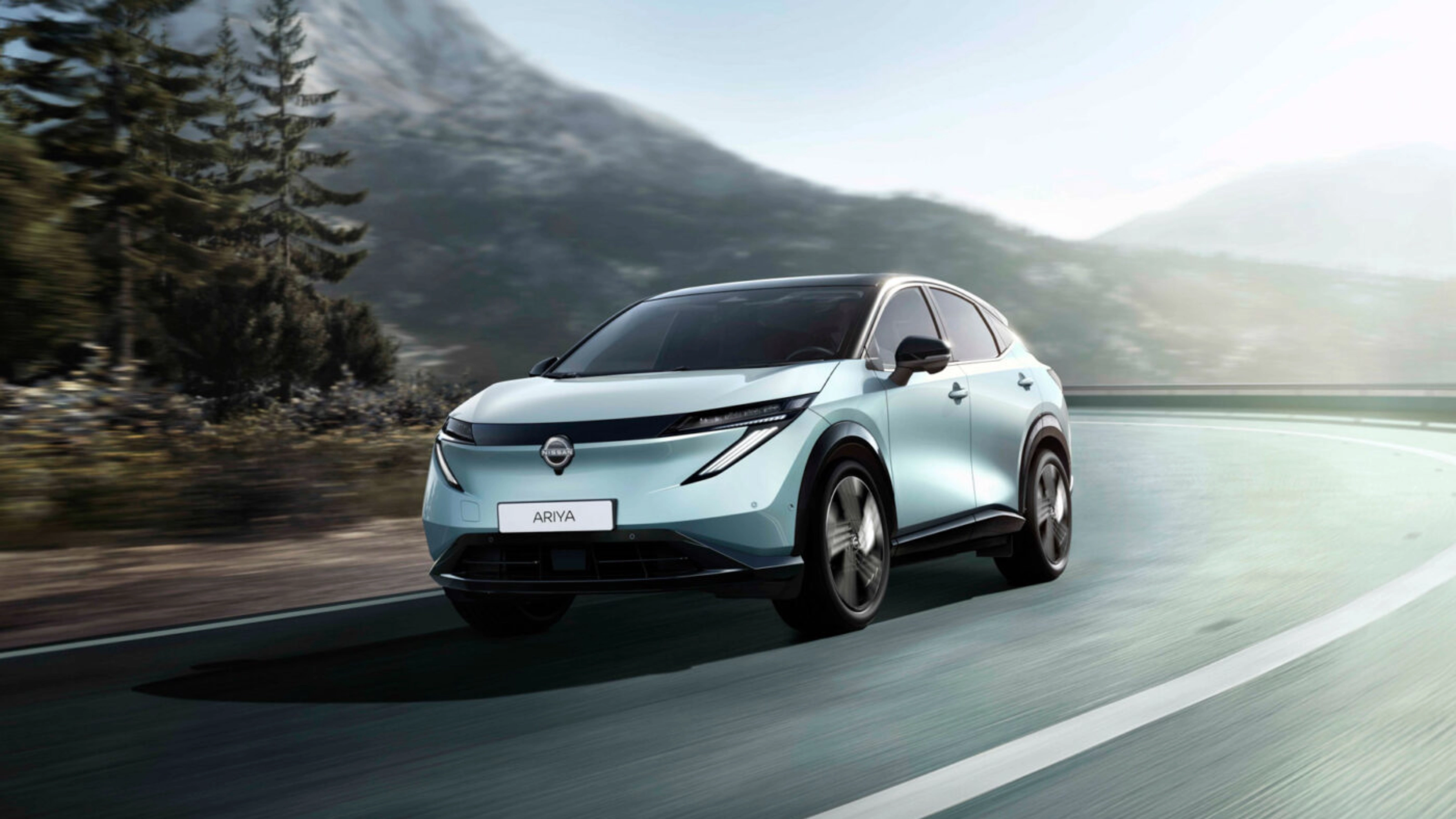 Nissan Ariya electric SUV driving on a mountain road.