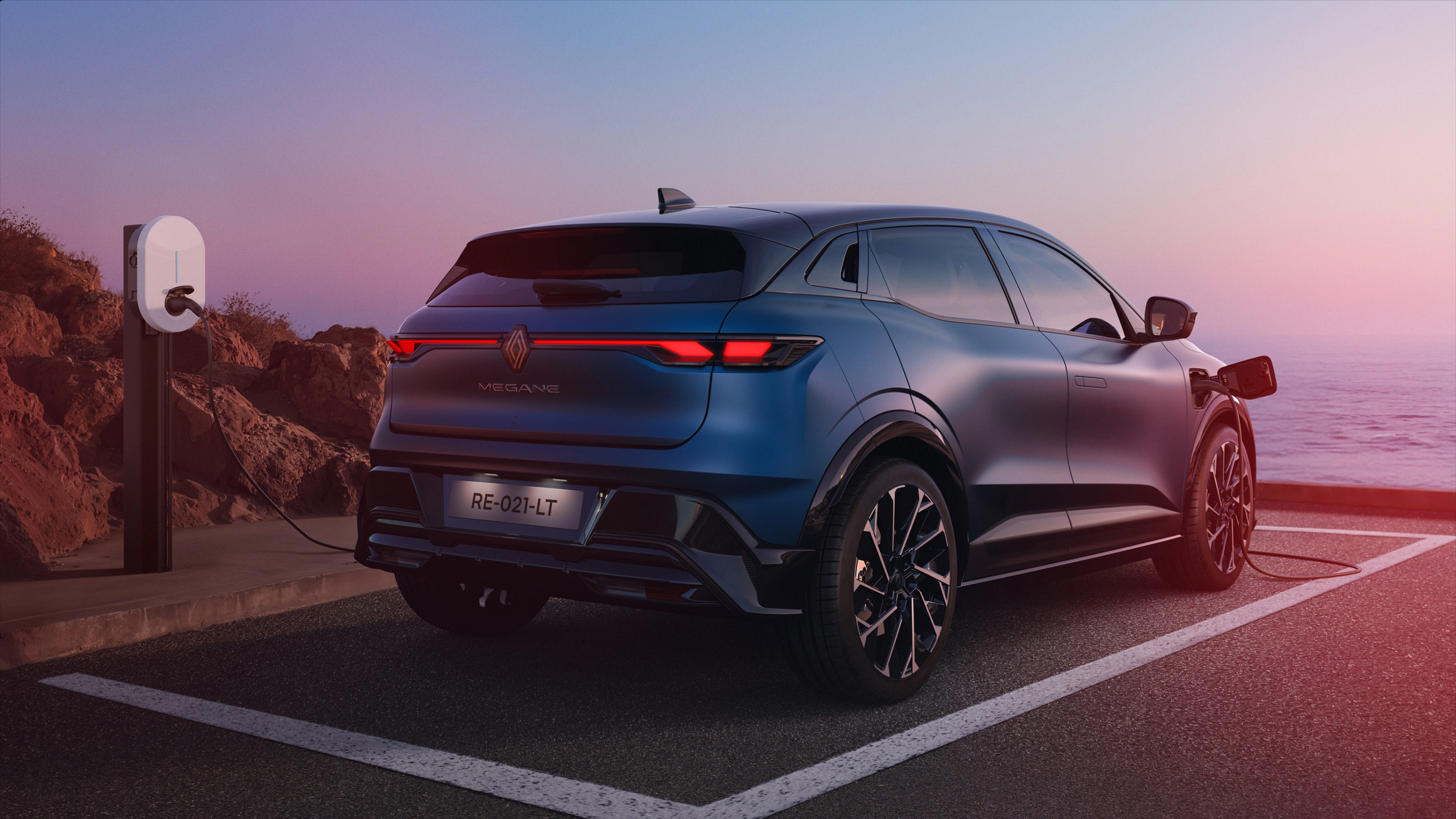 Heckansicht eines Renault Megane E-Tech beim Laden an einer E-Ladestation.