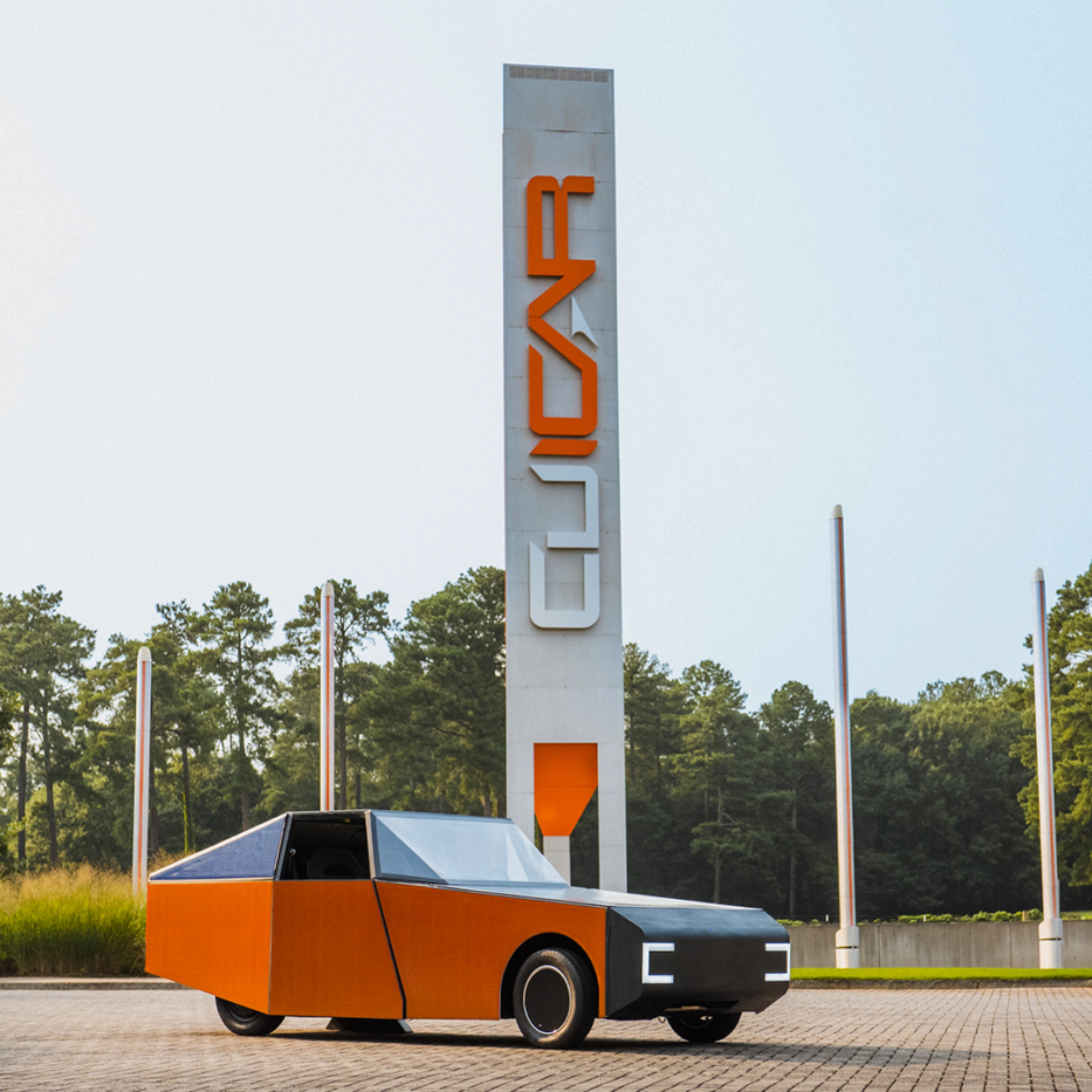 Autonomous vehicle beside a CU-ICAR test tower at Clemson University.