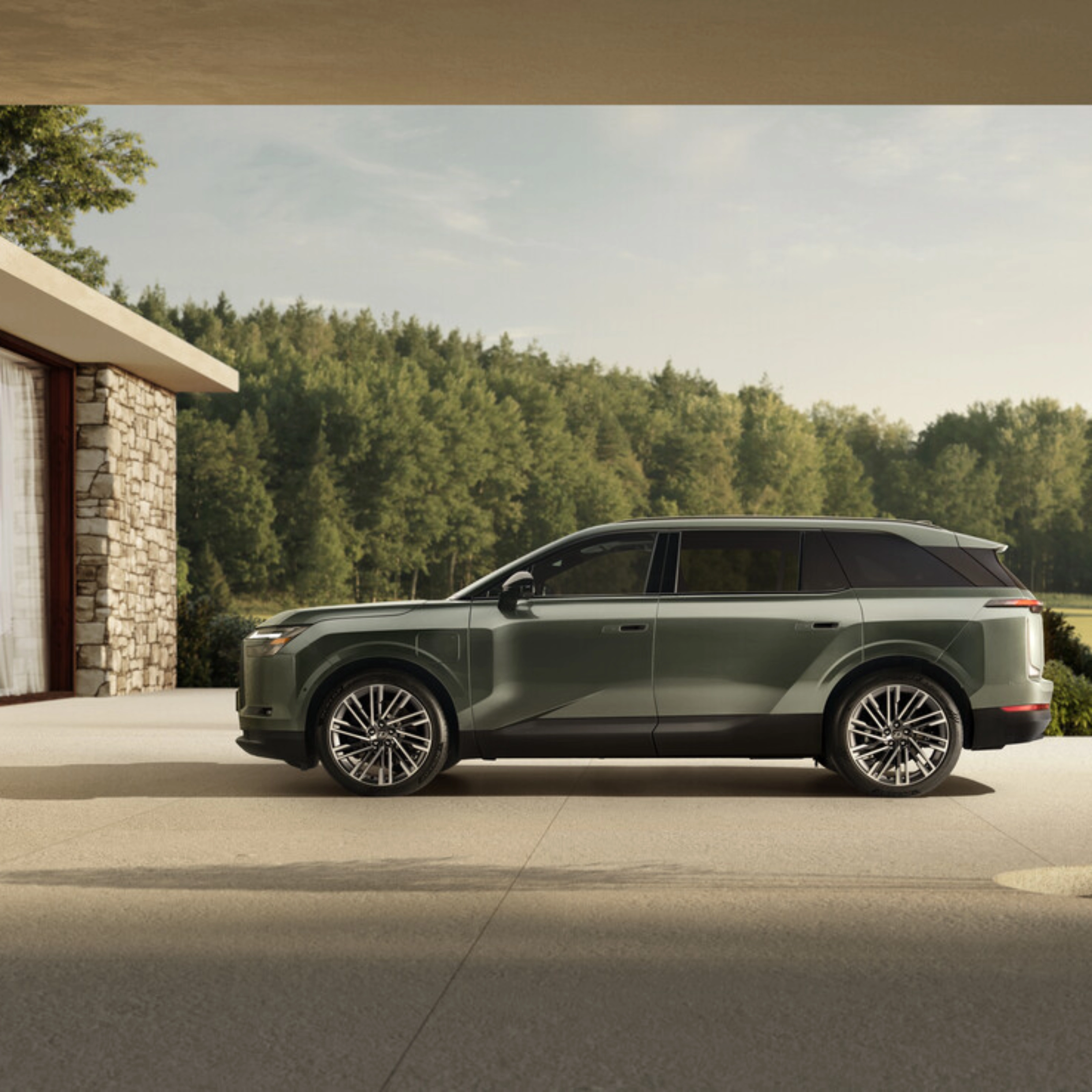 Grünes Toyota Elektro-SUV neben modernem Steinhaus geparkt.