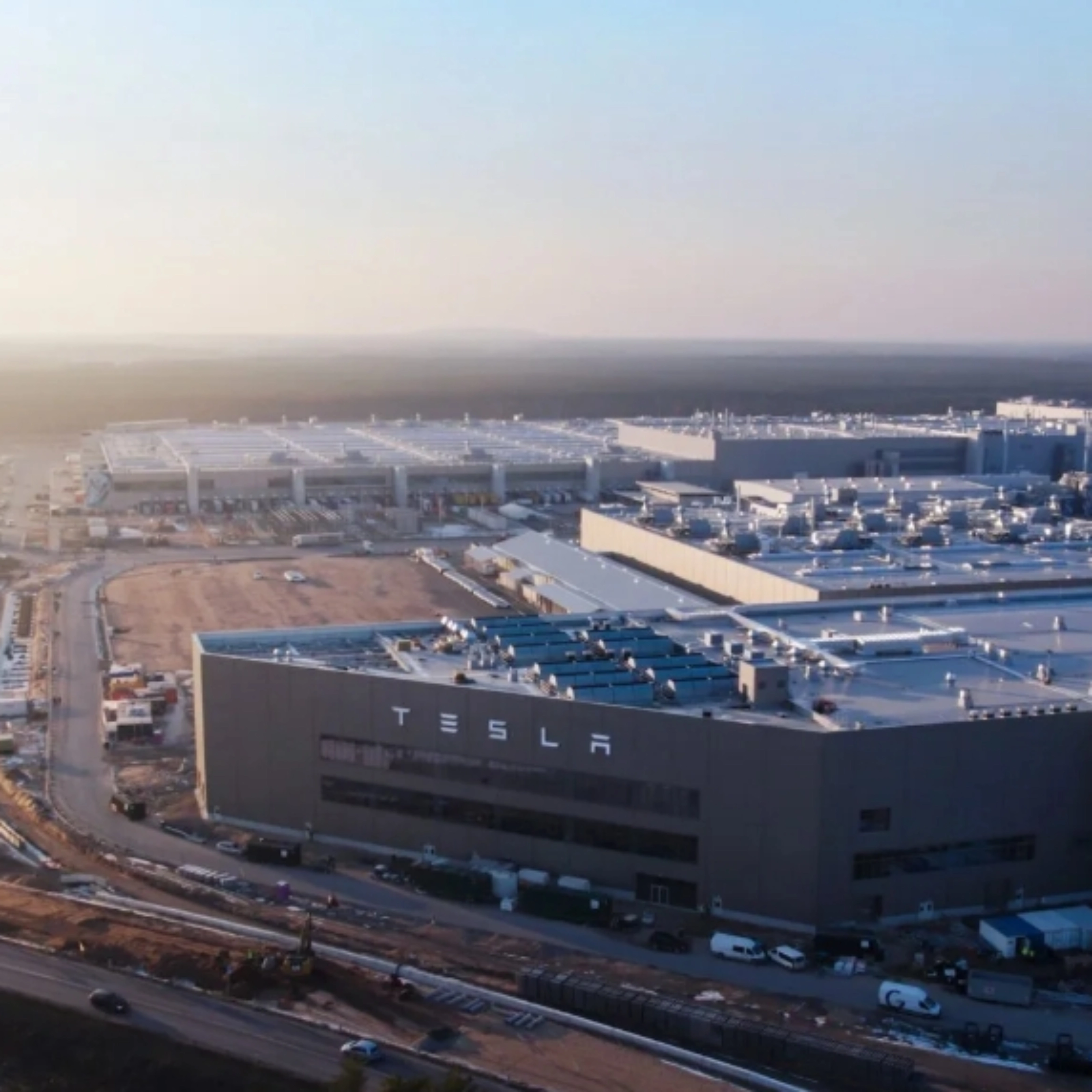 Luftaufnahme eines Tesla-Werks mit großen Produktionsgebäuden.