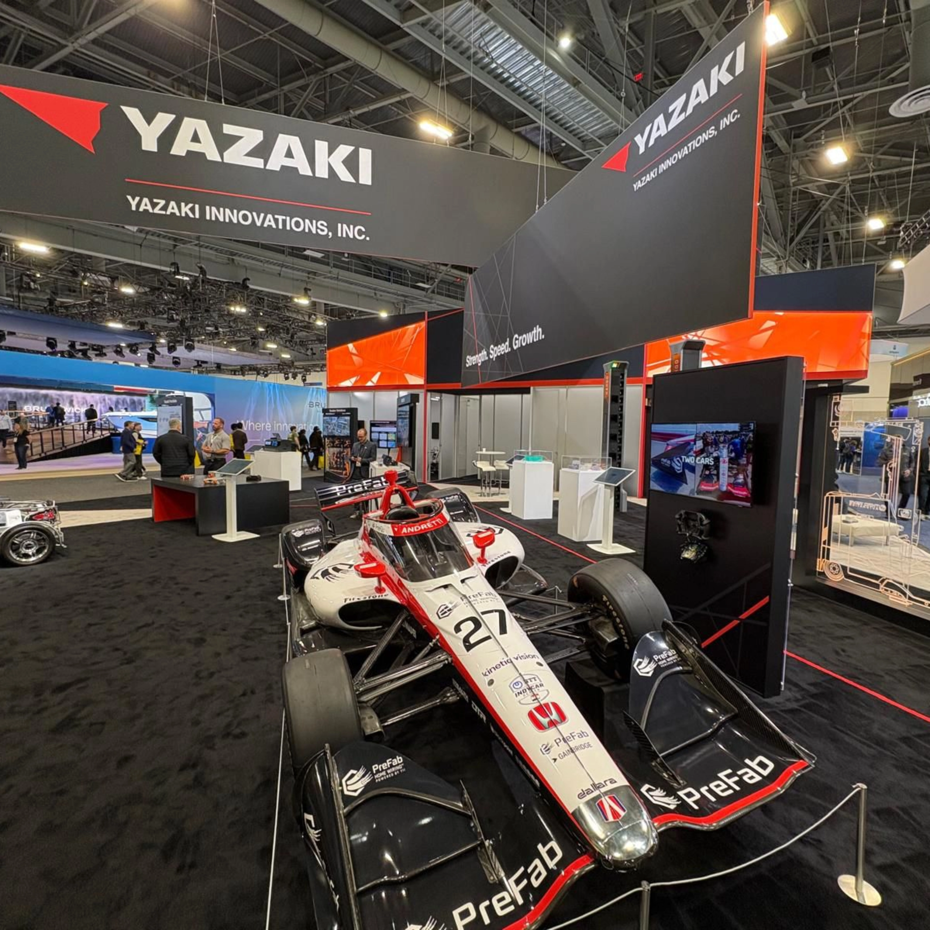 Ein Rennwagen steht am Messestand von Yazaki auf einer Technologiemesse.