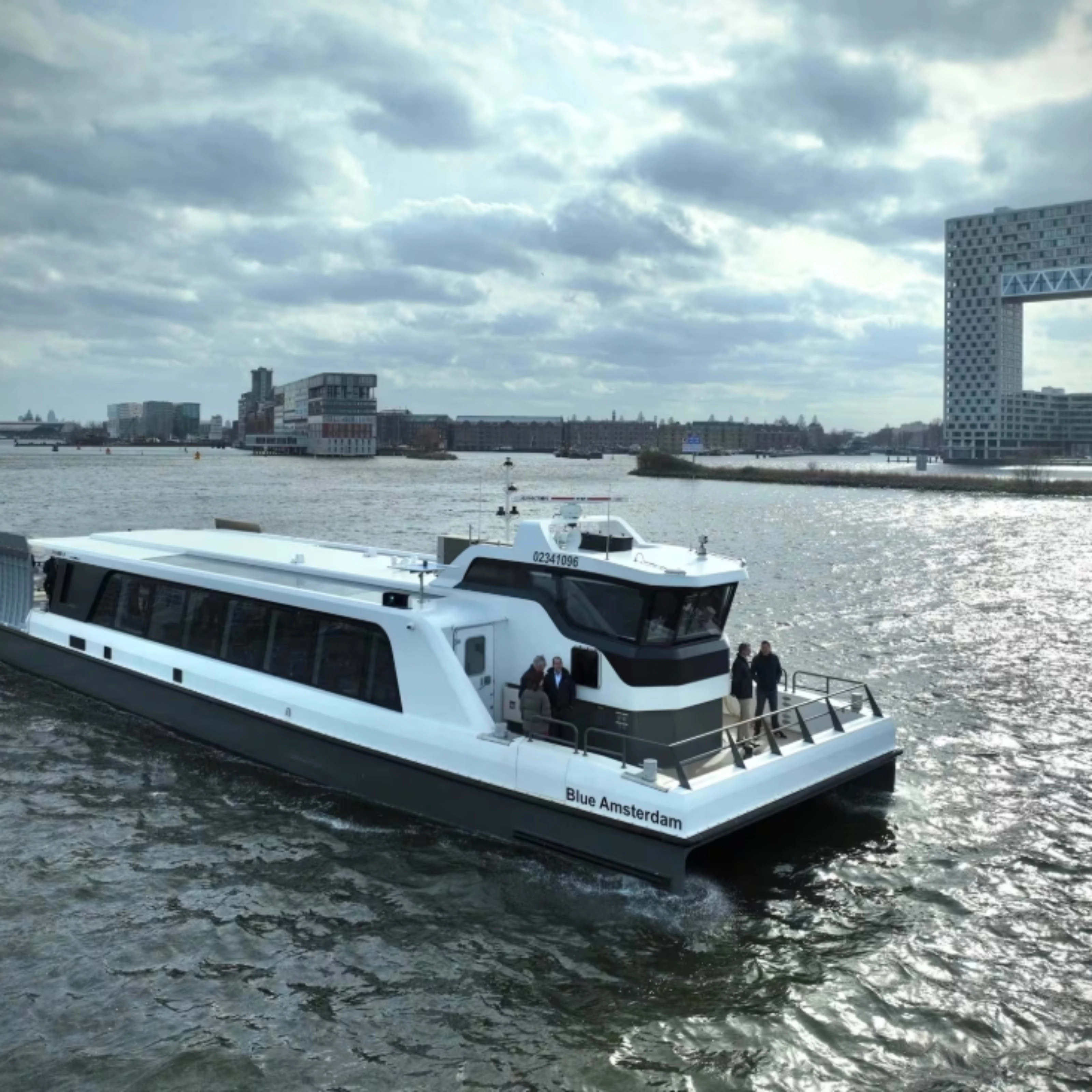 White passenger ferry on a river with modern city buildings in background