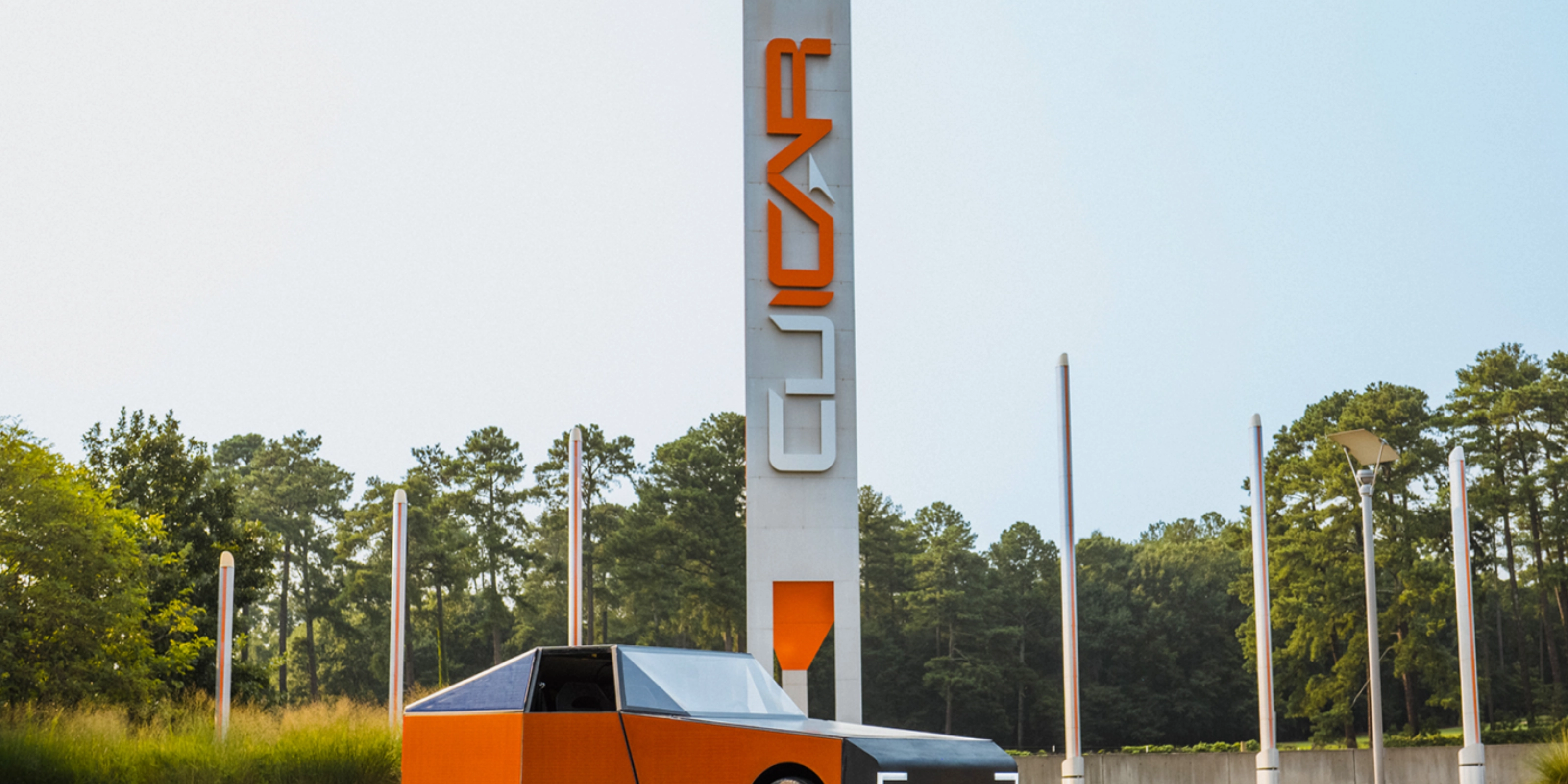 Autonomous vehicle beside a CU-ICAR test tower at Clemson University.