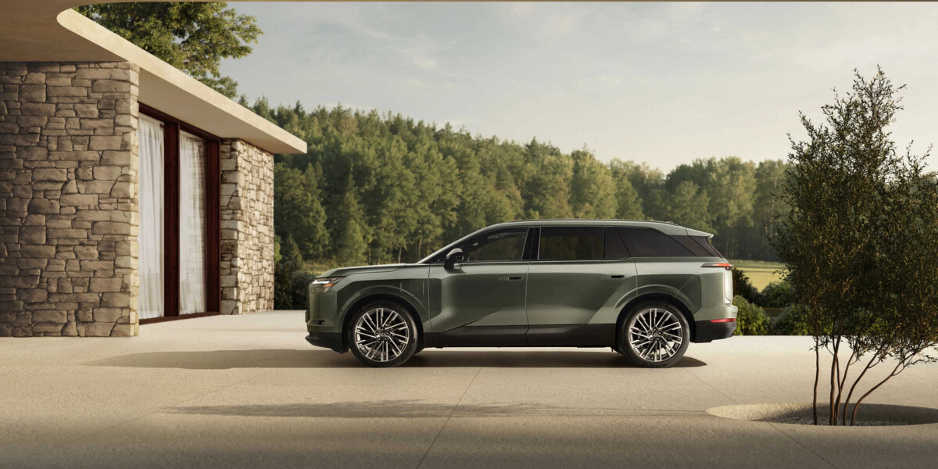 Grünes Toyota Elektro-SUV neben modernem Steinhaus geparkt.