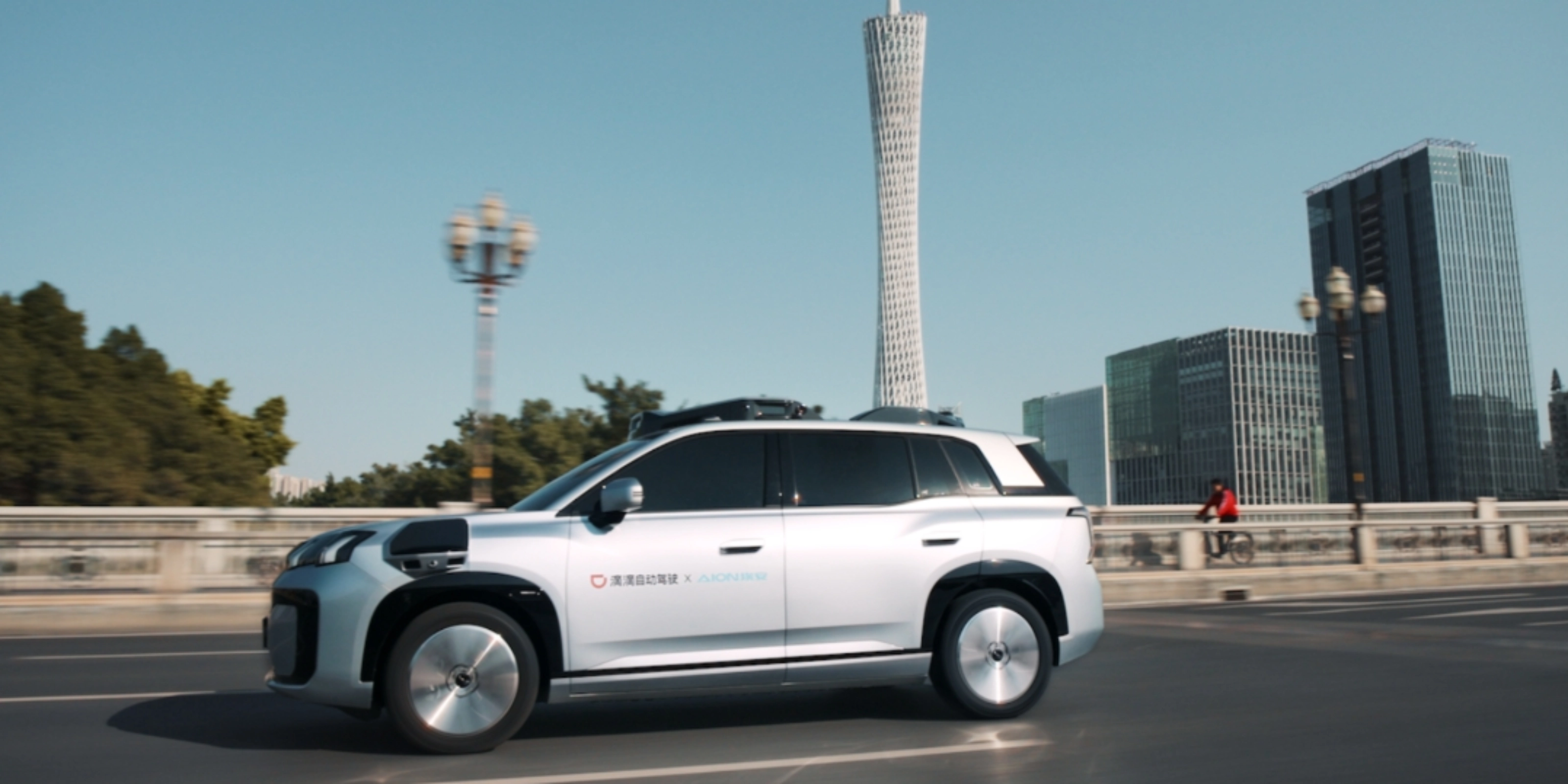 Ein autonomes SUV fährt durch eine Stadt mit modernen Gebäuden im Hintergrund.