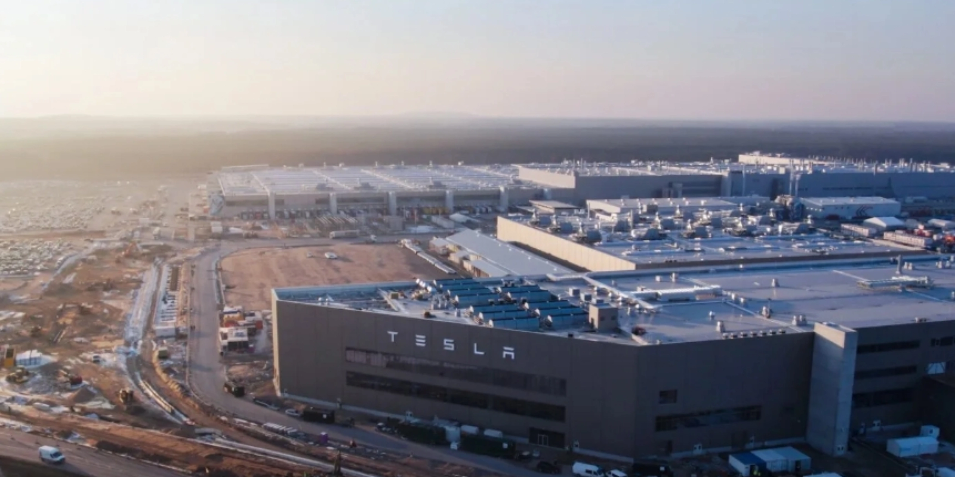 Luftaufnahme eines Tesla-Werks mit großen Produktionsgebäuden.