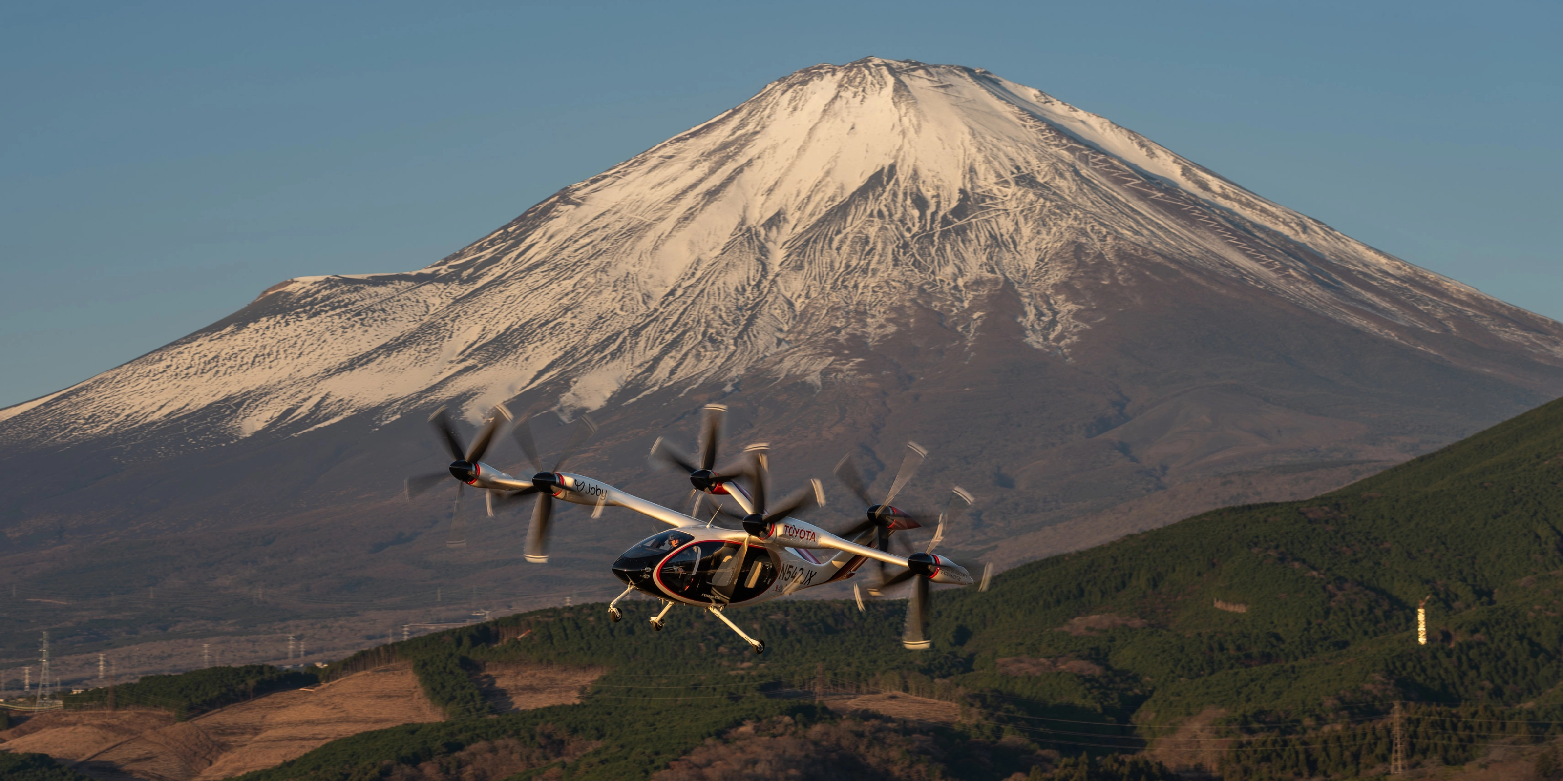 Elektrisches Flugtaxi von Joby Aviation vor dem Berg Fuji im Flug.