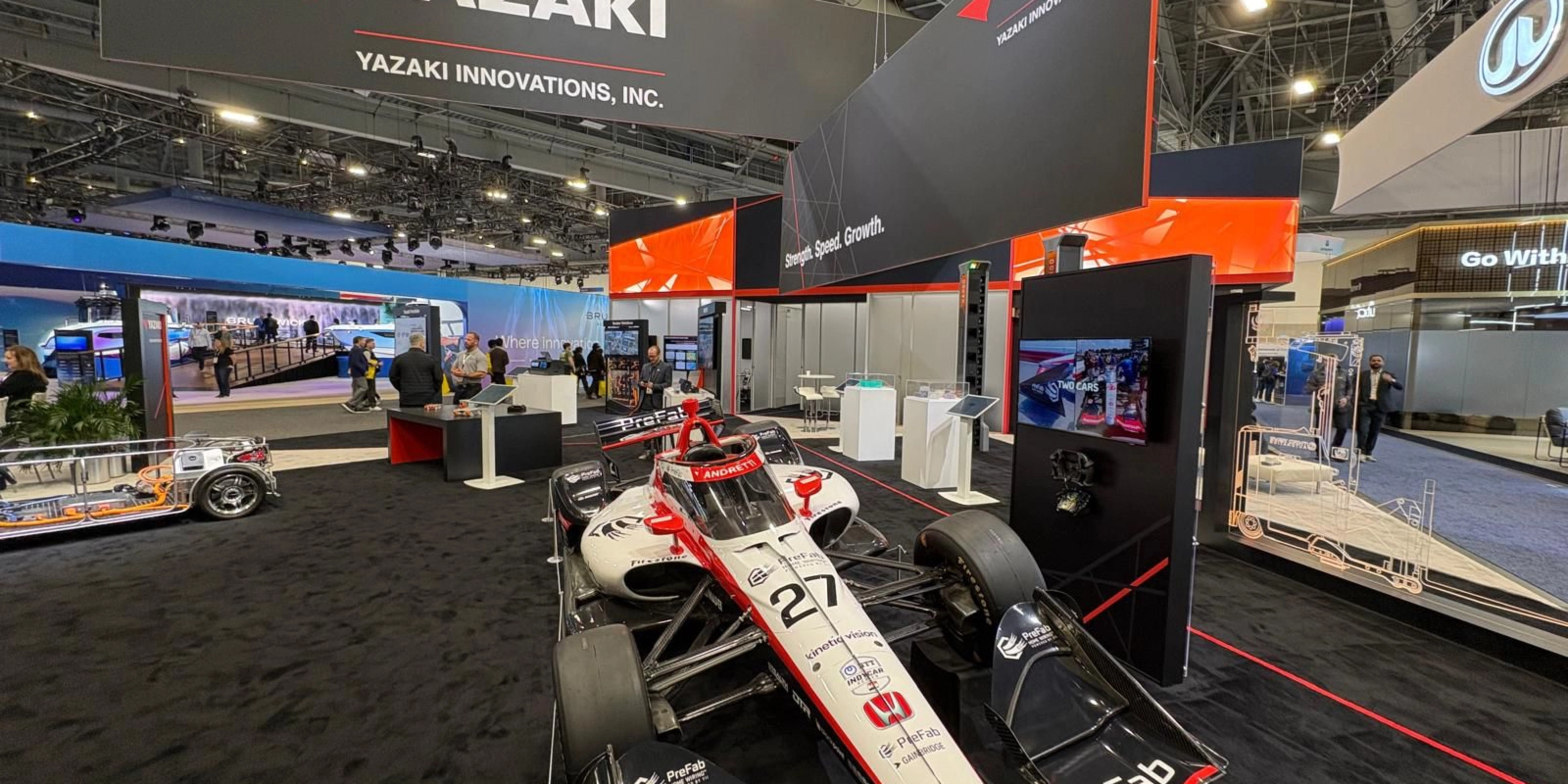 Ein Rennwagen steht am Messestand von Yazaki auf einer Technologiemesse.