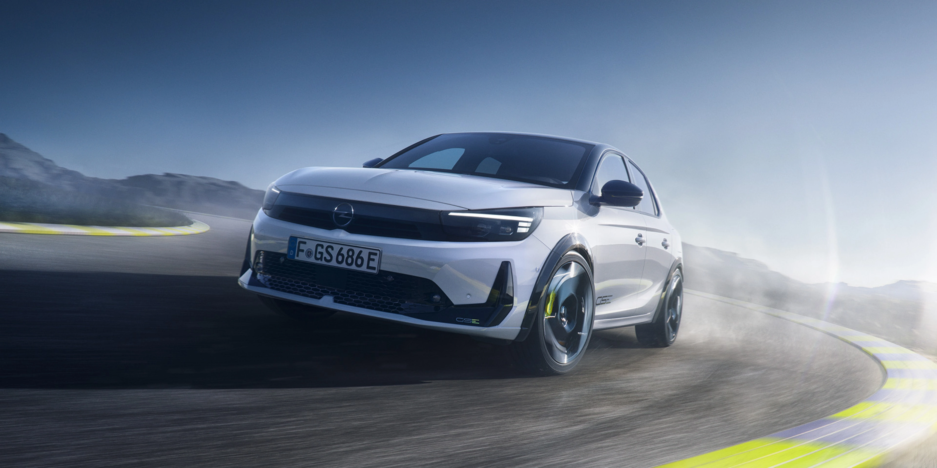 Opel GS Elektroauto fährt schnell in einer Kurve auf einer Rennstrecke.