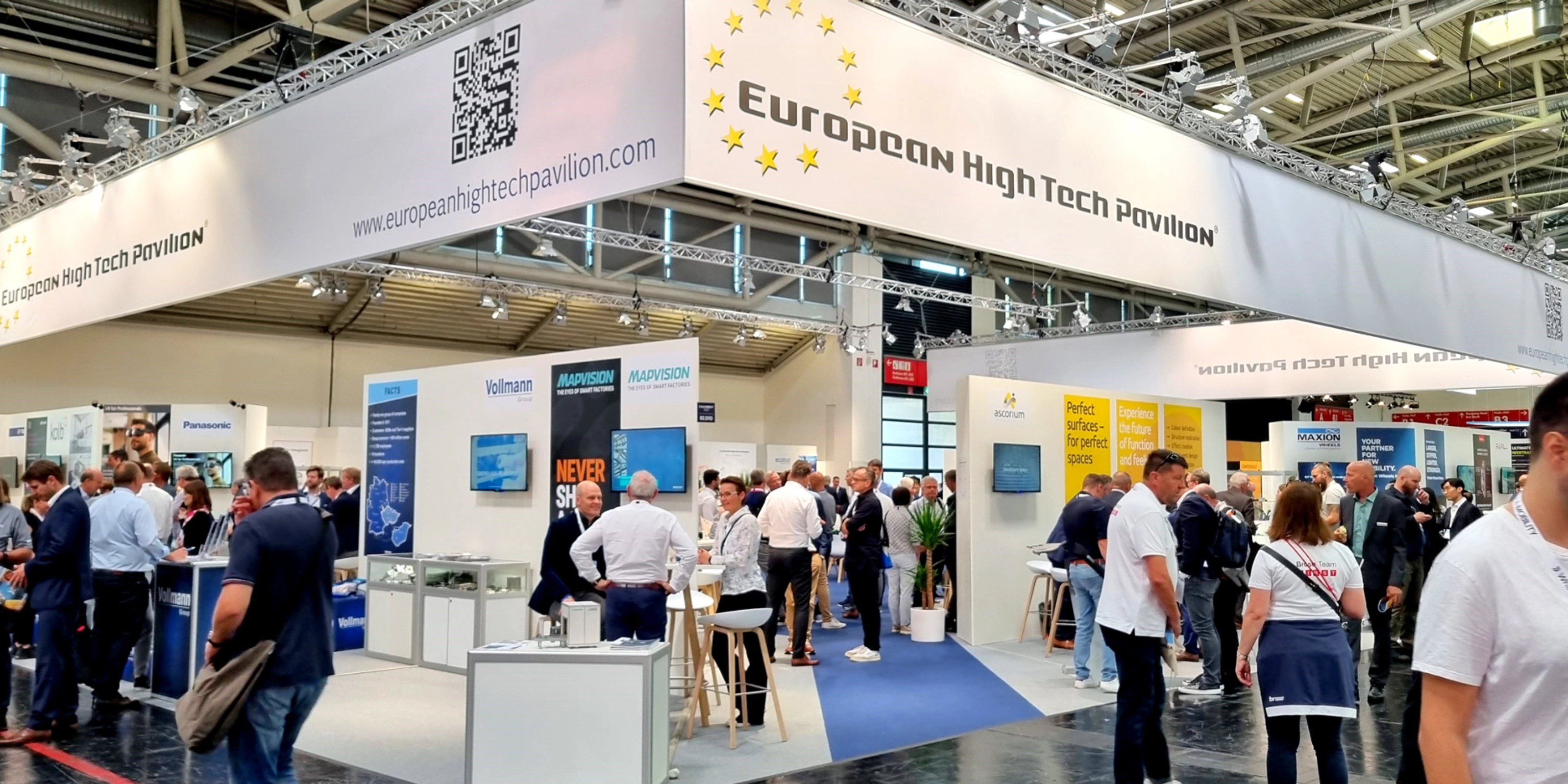 European High Tech Pavilion with many people networking at a busy trade fair.