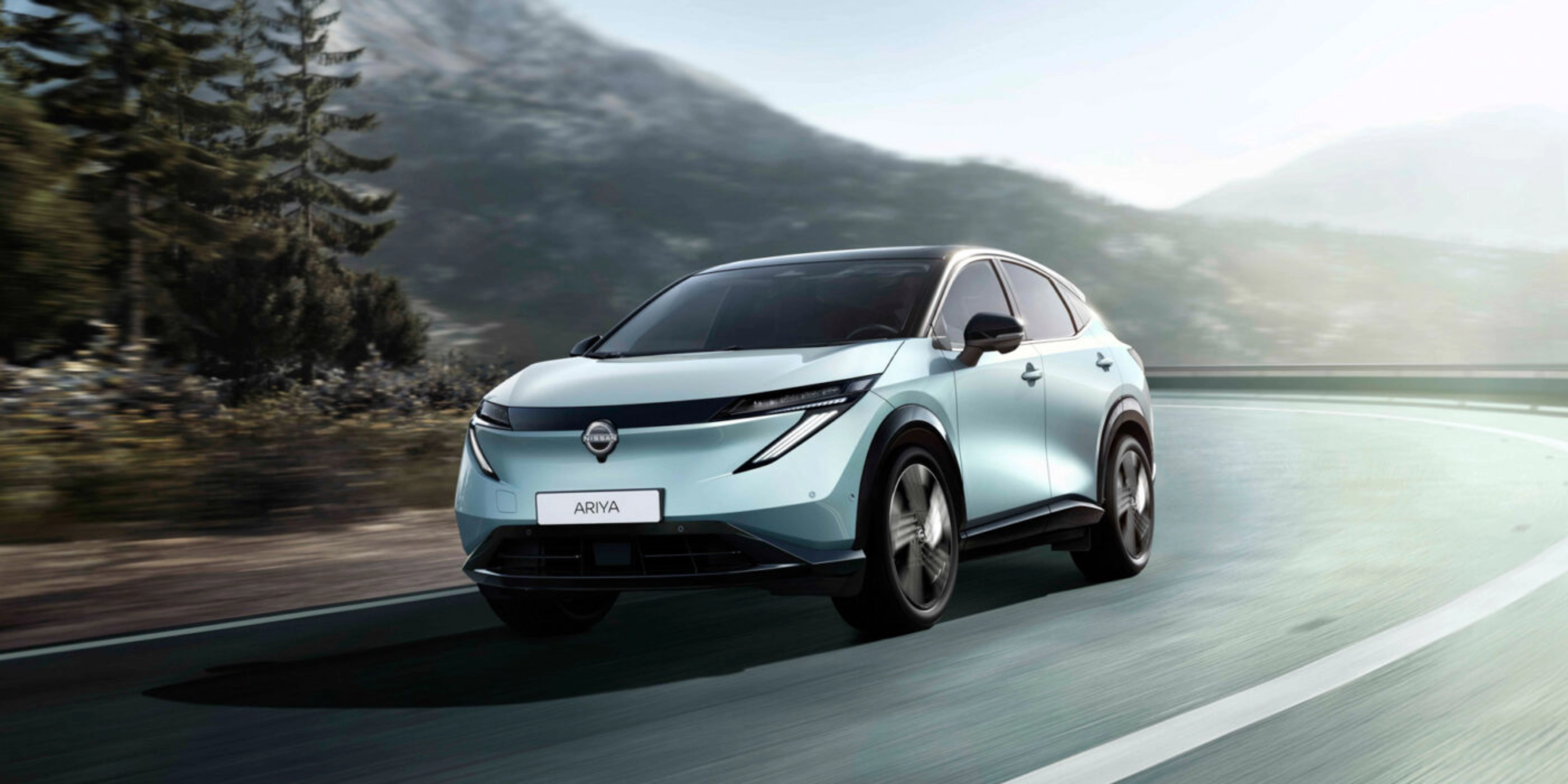 Nissan Ariya electric SUV driving on a mountain road.