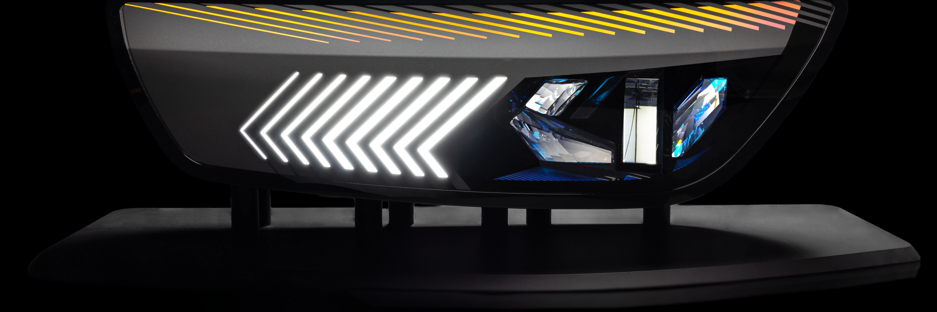 Close-up of a modern car tail light with animated red and yellow LED patterns.