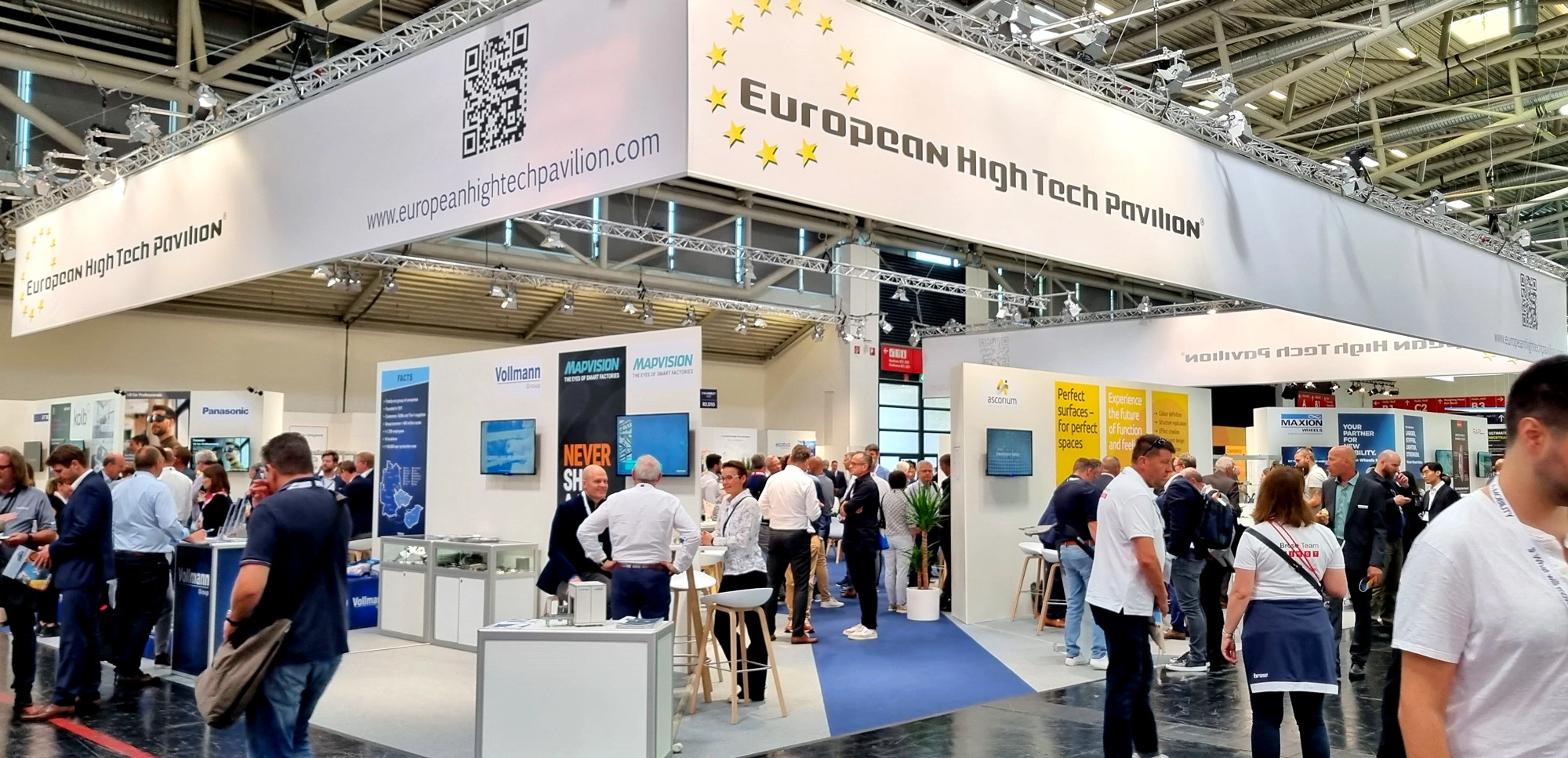European High Tech Pavilion with many people networking at a busy trade fair.