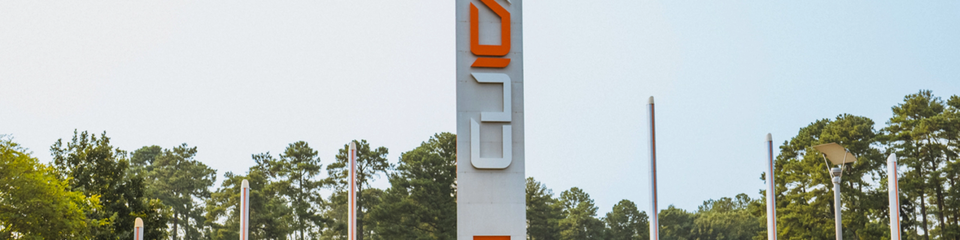 Autonomous vehicle beside a CU-ICAR test tower at Clemson University.