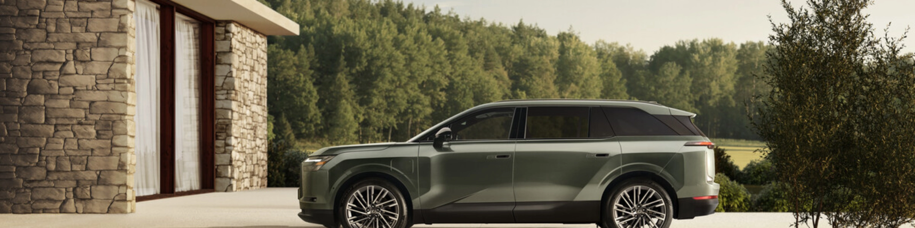 Grünes Toyota Elektro-SUV neben modernem Steinhaus geparkt.