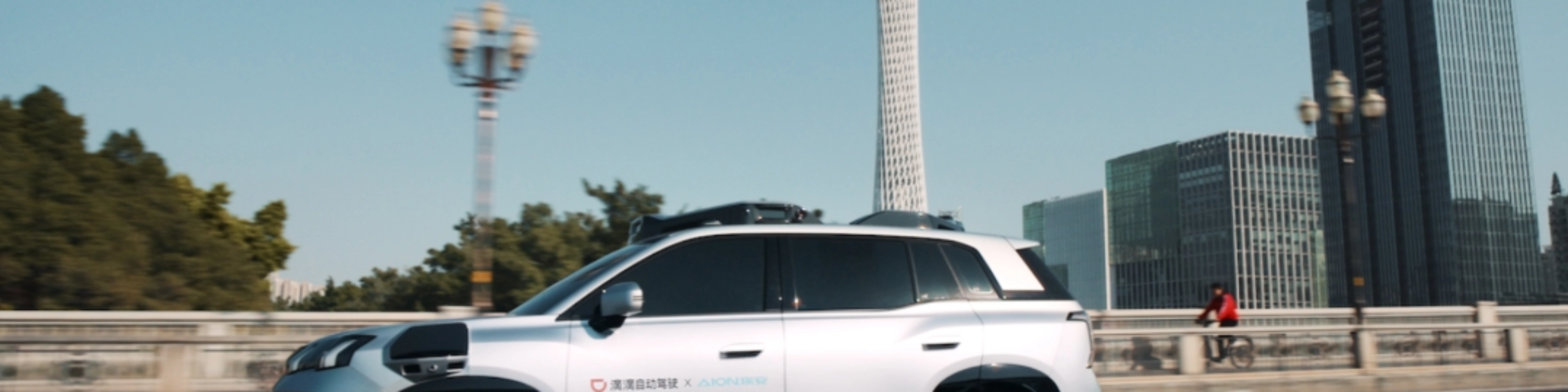 Ein autonomes SUV fährt durch eine Stadt mit modernen Gebäuden im Hintergrund.