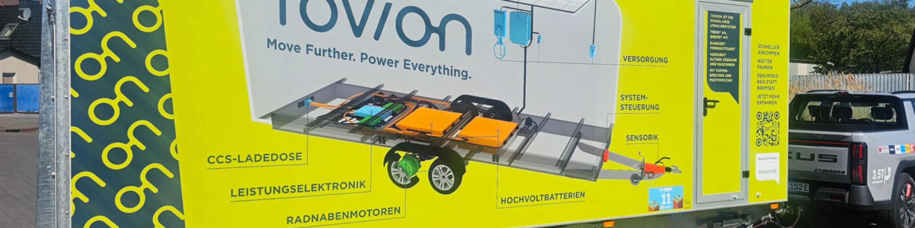 Yellow Tovion trailer with product graphic parked outdoors.